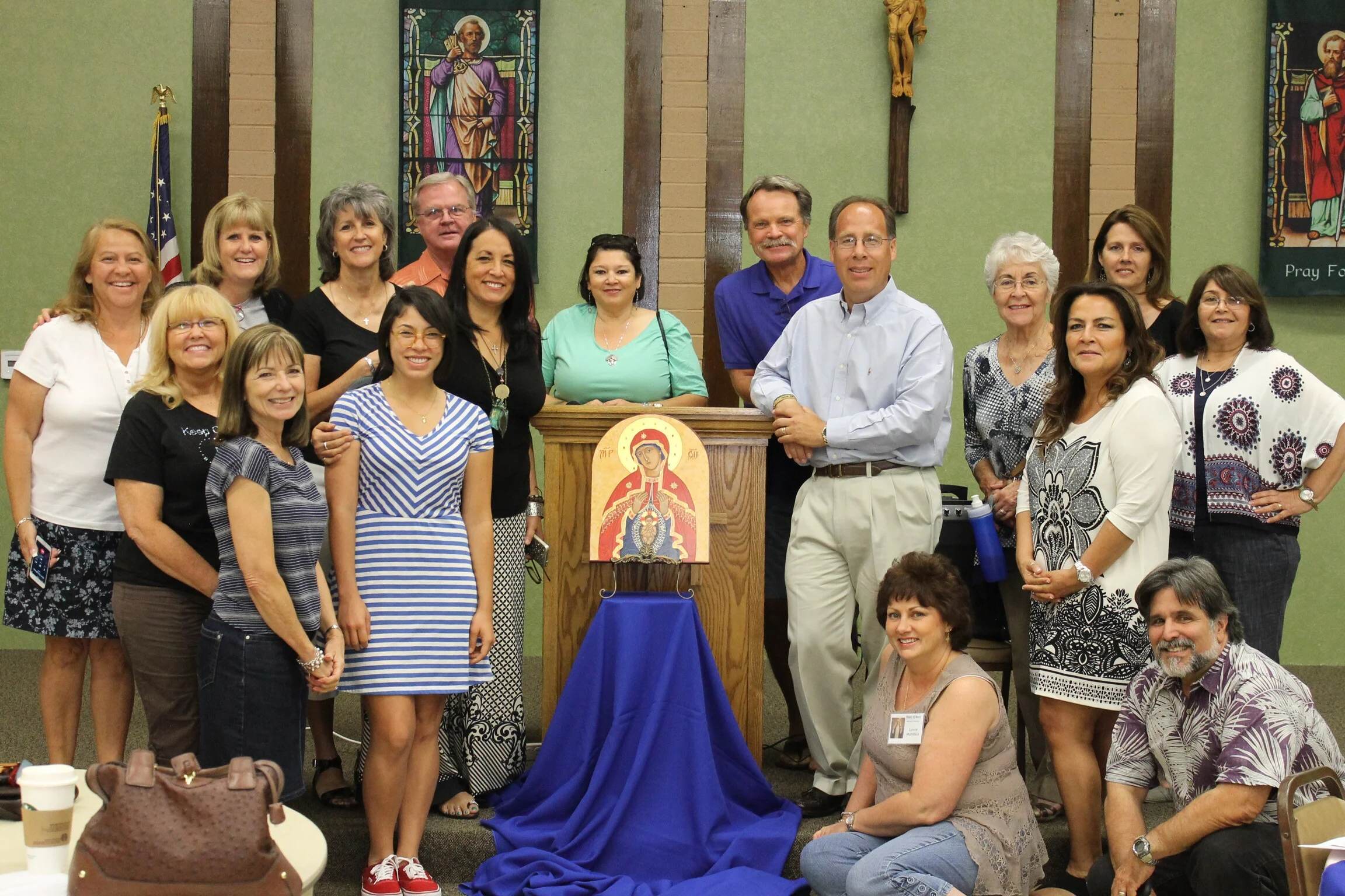 Tom Imbruglia (light blue shirt + khakis) at our Heart of Mary Women's Fellowship meeting in Alta Loma, CA; surrounded by a handful of attendees. 