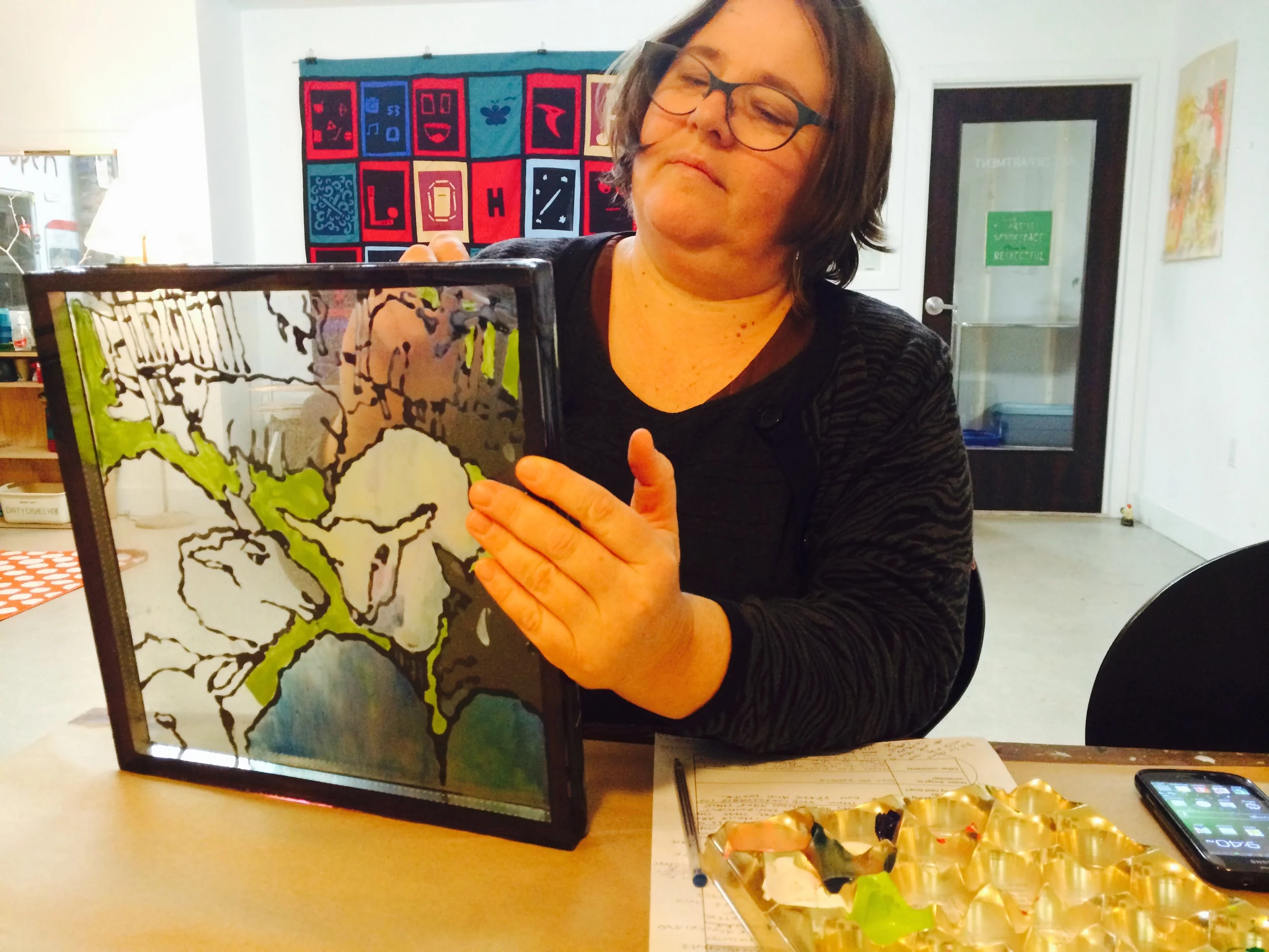After cleaning up and rearranging the room, Heather works on her glass painting piece. These little sheep are for one of our board members, who has a farm and many lambs to take care of starting at this time of year.