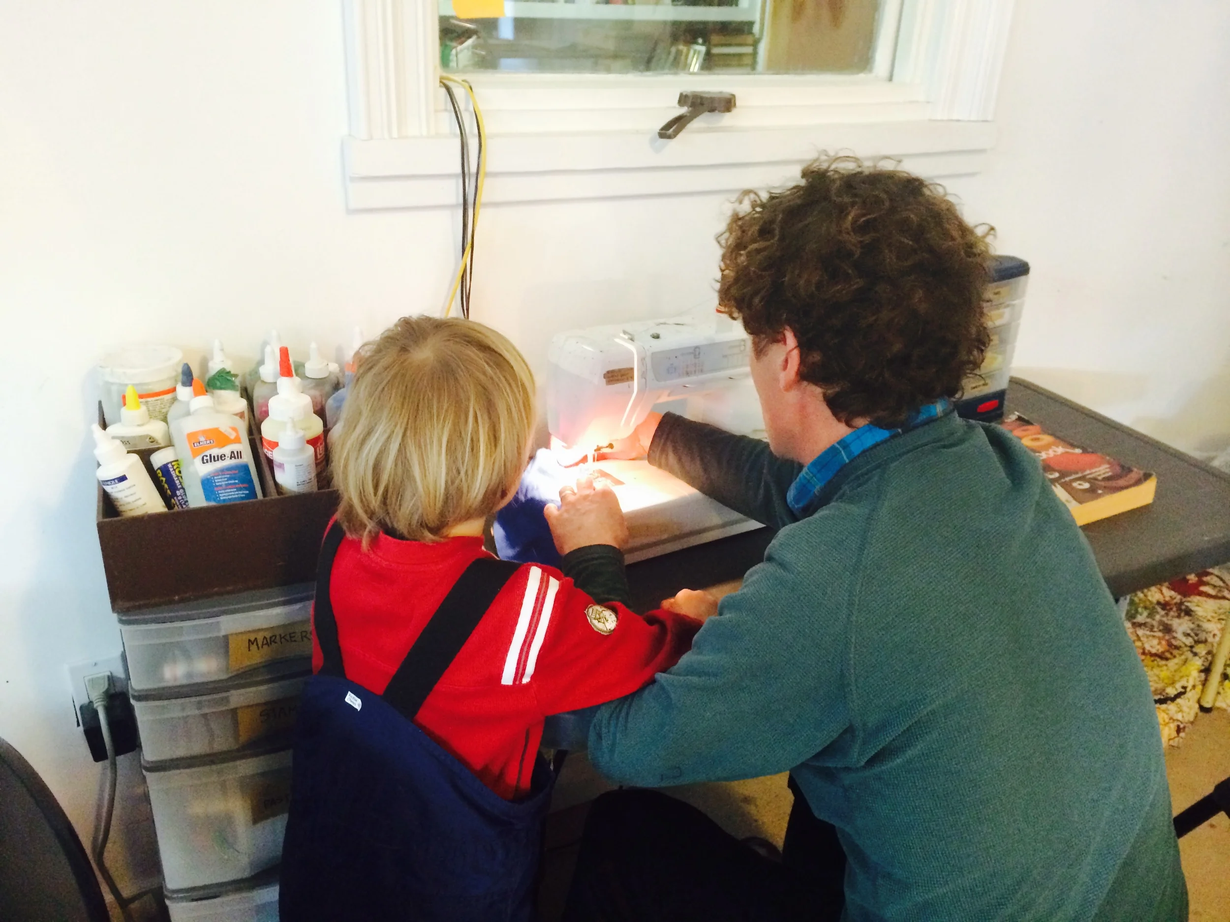 A dad and son sewing together to make a pillow. Loved that the dad hadn't sewn before but because his mom had sewn, and he had grown up surrounded by machines and projects, 'by osmosis' he knew how. 