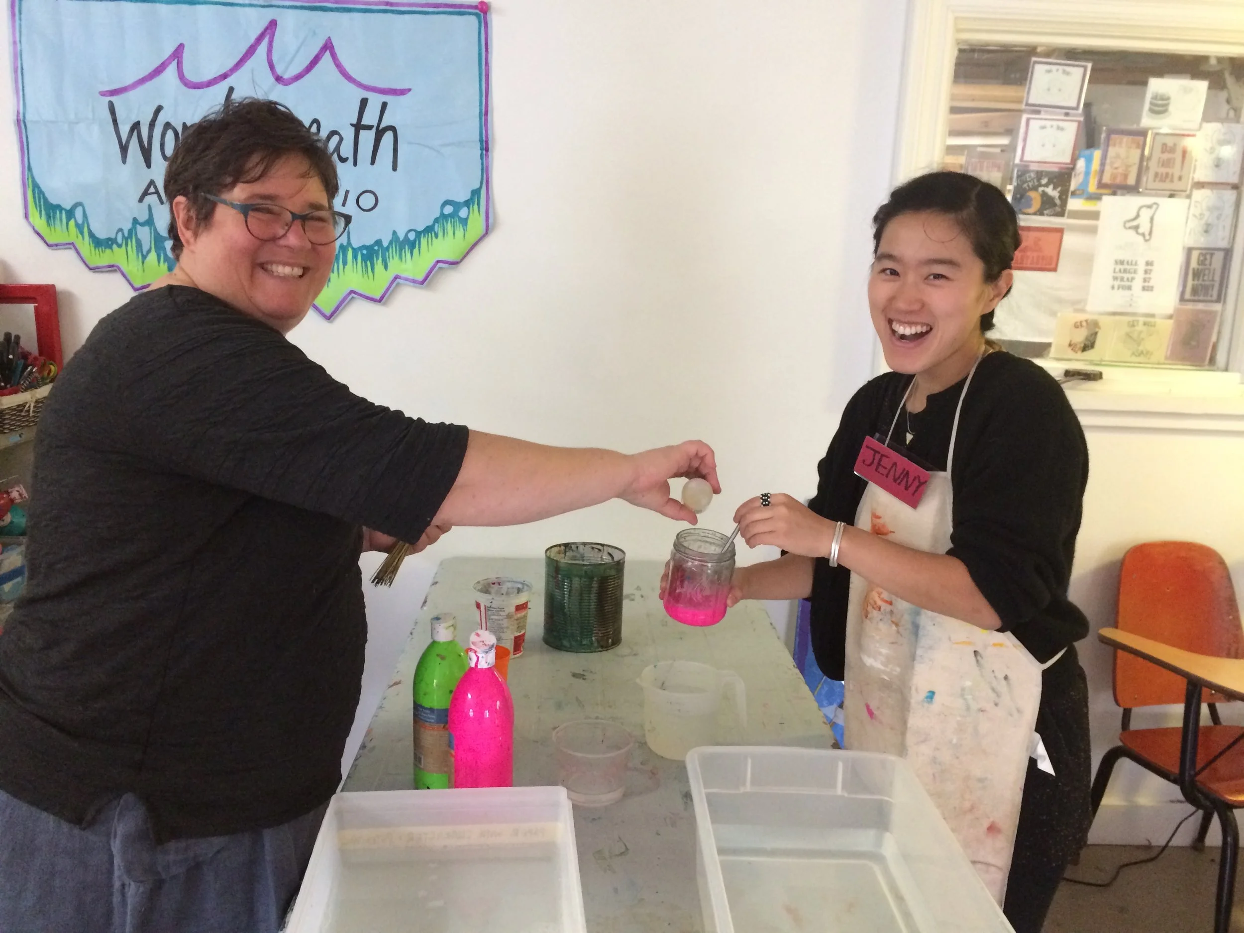 Facilitators Heather and Jenny testing out a new paper marbling technique before Open Studio begins.