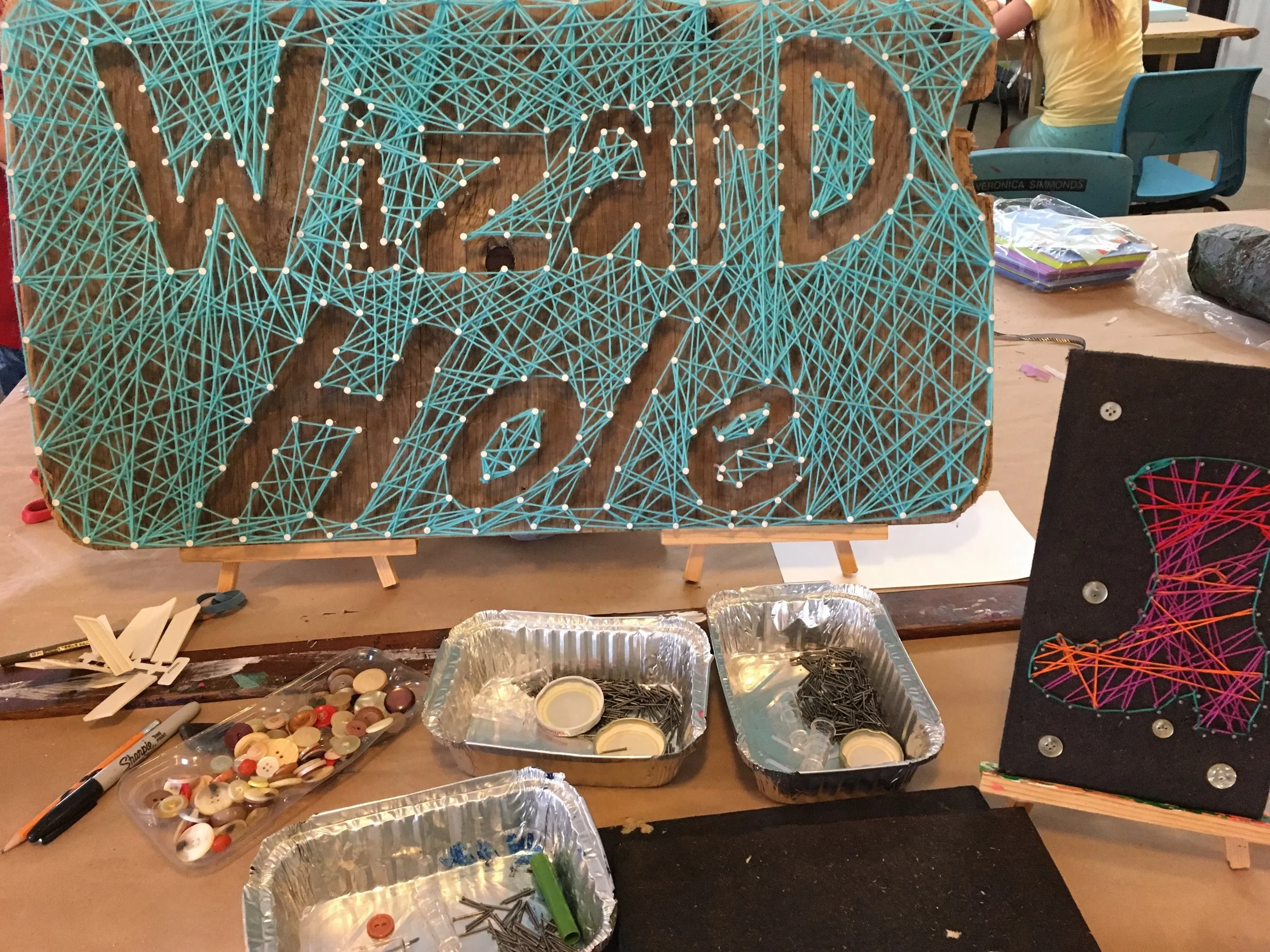 Some days we invent or research really interesting projects to share during Open Studio. On other days we are rushing to transition the studio from one event to another and we end up looking around for inspiration. Luckily, we share the space with incredibly creative (and weird) folks like the wizards (aka ceramic artists). Thanks for sharing this awesome sign with us on our string art exploration day!