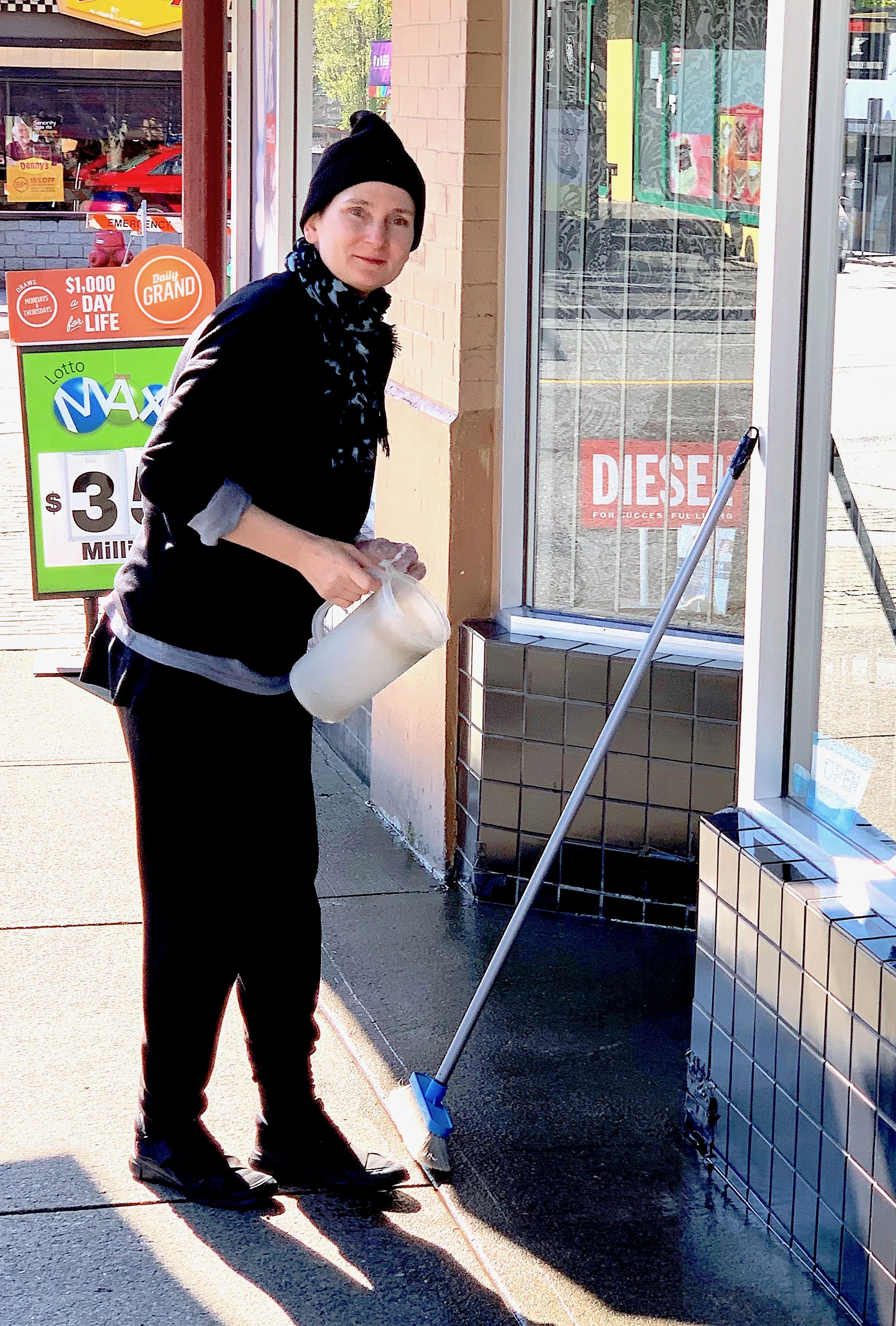 Linda K. polishes up the entrance to State of Mind one last time, closing day on Sunday, April 28.