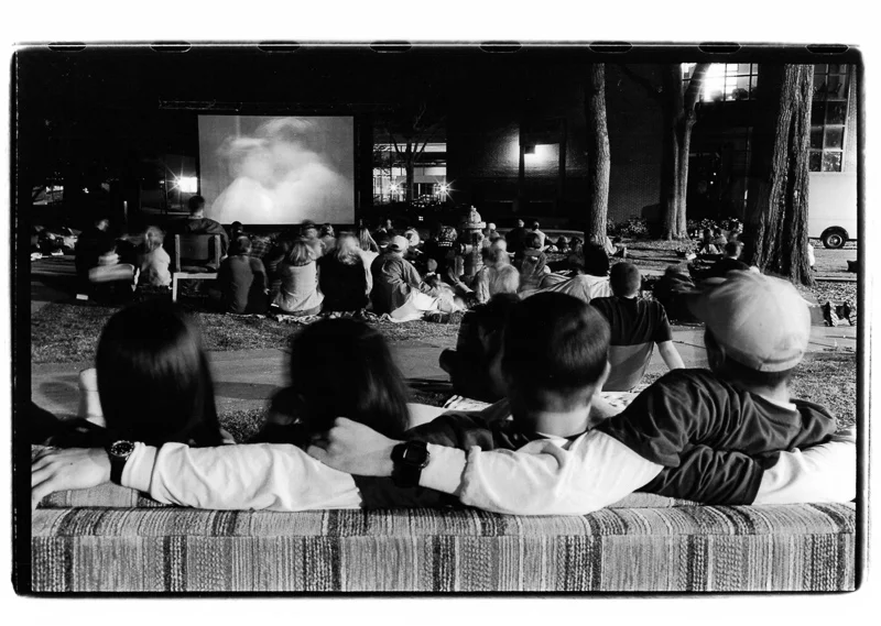 many people wathing an outdoor movie