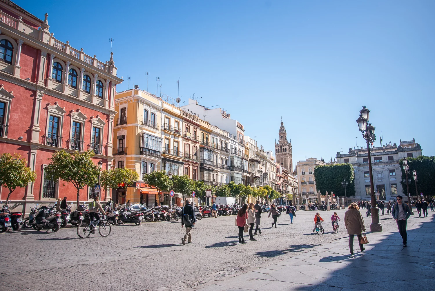 San Francisco Square ( Plaza de San Francisco) with Giralda Tower (ancient minaret of the old mosque of Sevilla) The pink building was the Royal Court in the 16th century