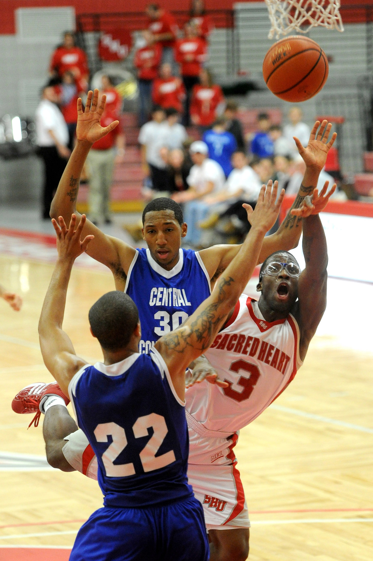  Sacred Heart University's Jerrell Thompson puts up a shot as he is defended by Ken Horton, back, and Devan Bailey, front, at CCSU in Fairfield on January 13, 2011. 