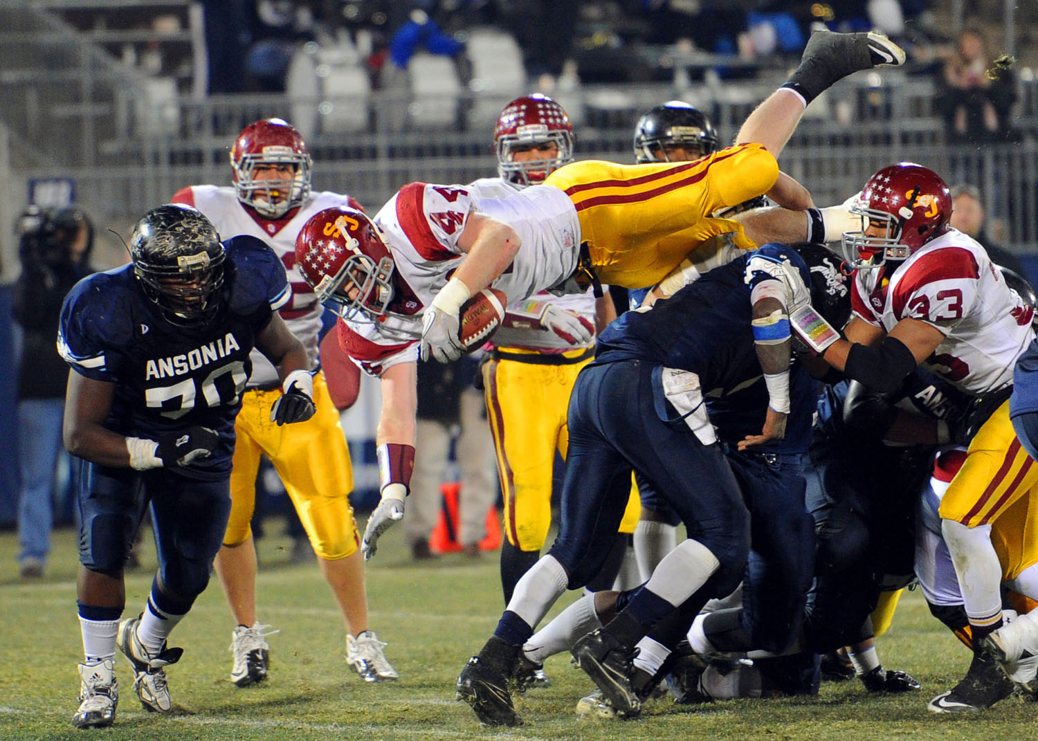 St. Joseph's Tyler Matakevich dives over Ansonia's defense to score a touchdown during the Class S State Football Championship game in East Hartford on December 11, 2010.
