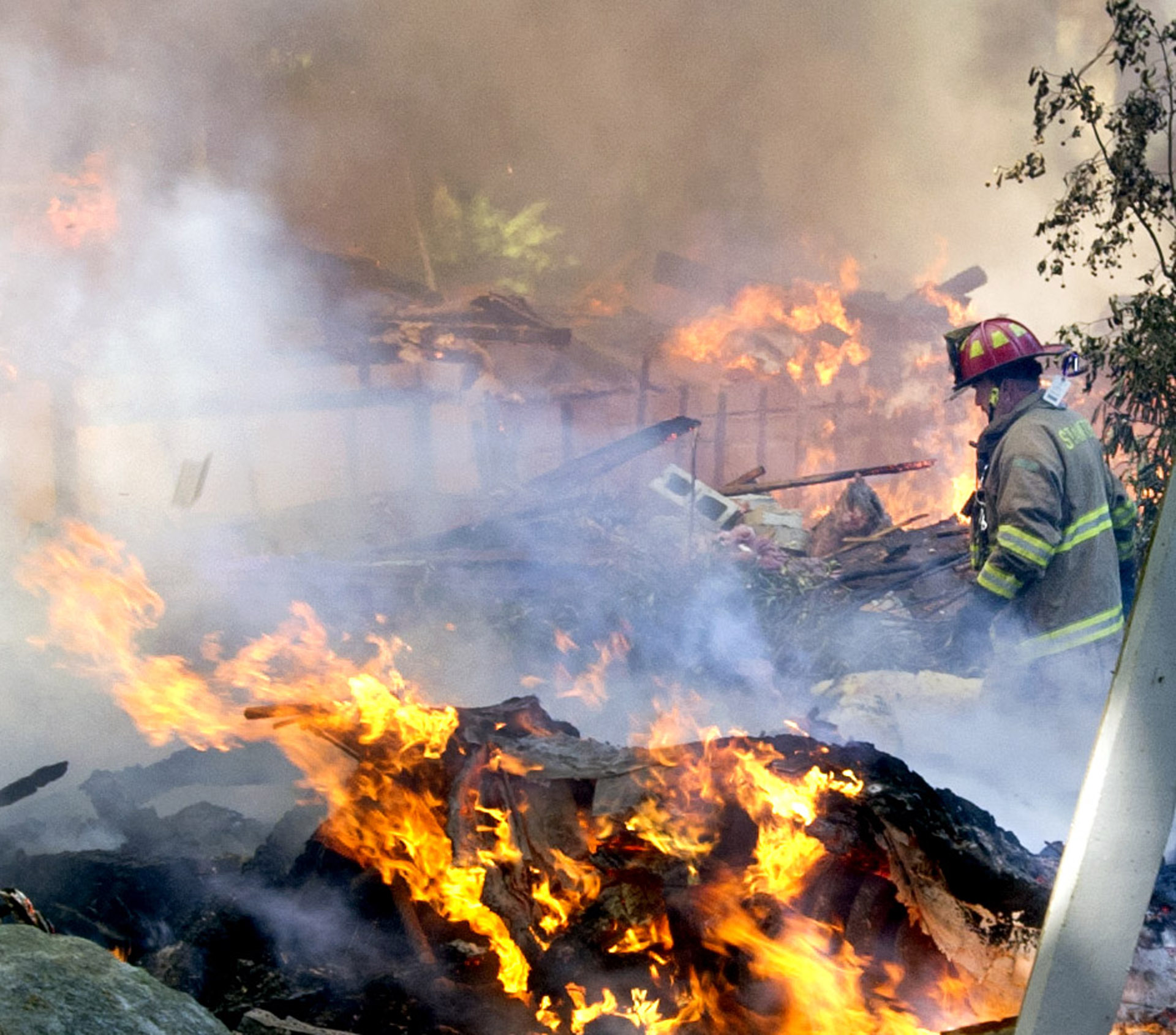  A firefighter walks through the burning rubble of 305 Webbs Hill Road in Stamford, Conn., where the home exploded on Tuesday, Sept. 17, 2013. 
