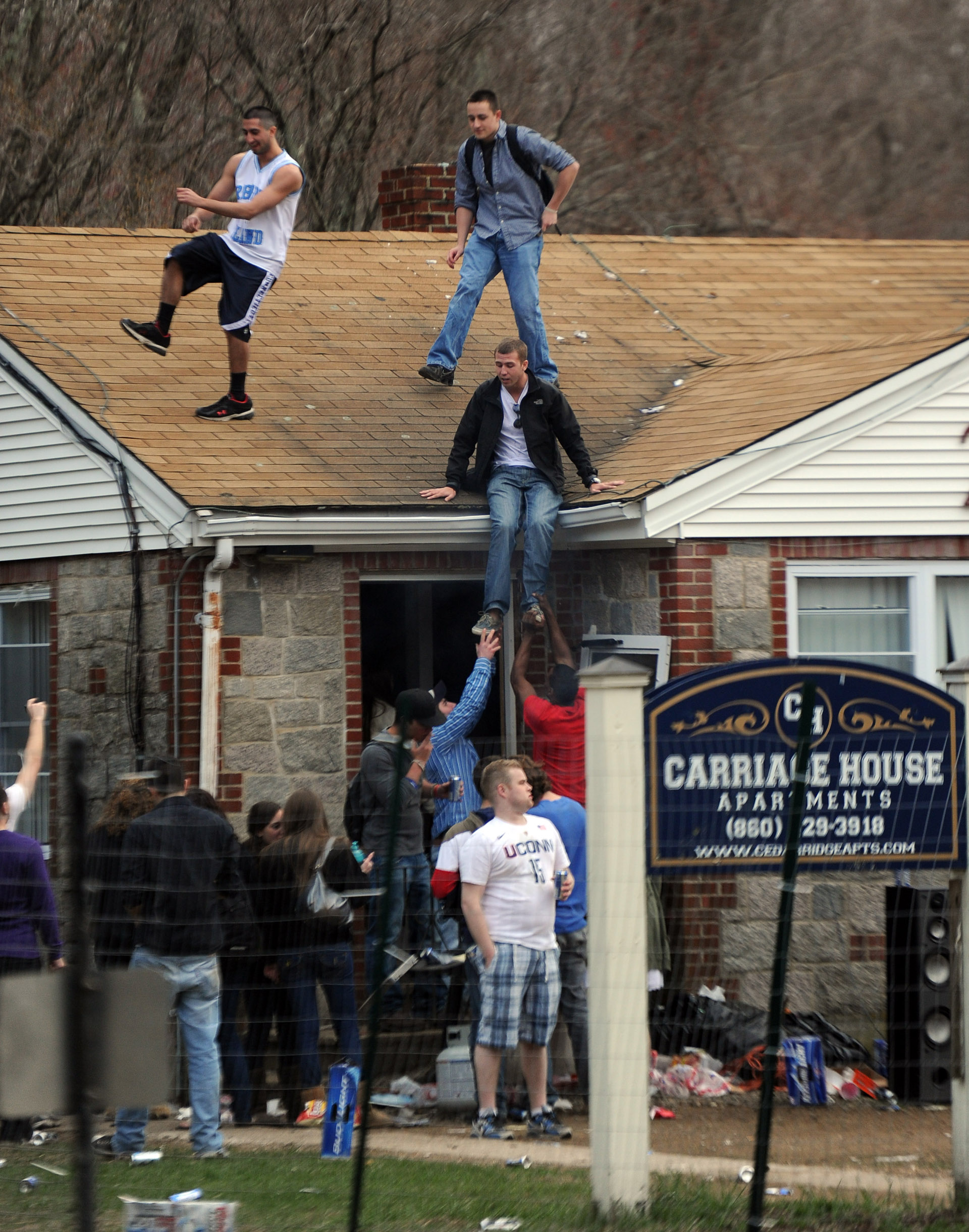  Party-goers stand on the roof of an apartment at the Carriage House Apartments during Spring Weekend at the University of Connecticut on Friday, April 22, 2011. 