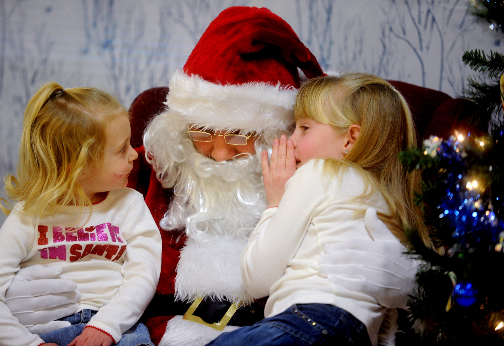 Morgan Sylvia, 6, whispers what she wants for Christmas in Santa's ear as her sister, Darby, 3, listens during the Ludlowe Center for Health & Rehabilitation in Fairfield.