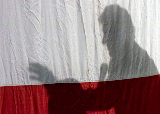  Former President Bill Clinton is silhouetted against the American flag as he speaks about his wife, Senator Hillary Clinton, at Ohio University-Chillicothe on Monday. 