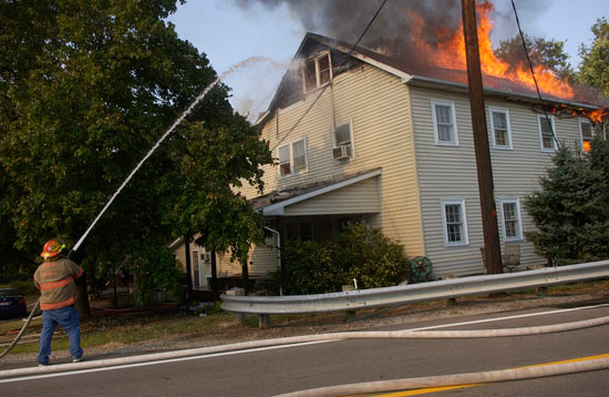  Bainbridge firefighter Larry Skaggs battles a blaze that claimed the home of Curtis Knapp on California Pike Monday afternoon. The two-story house was deemed a total loss. 