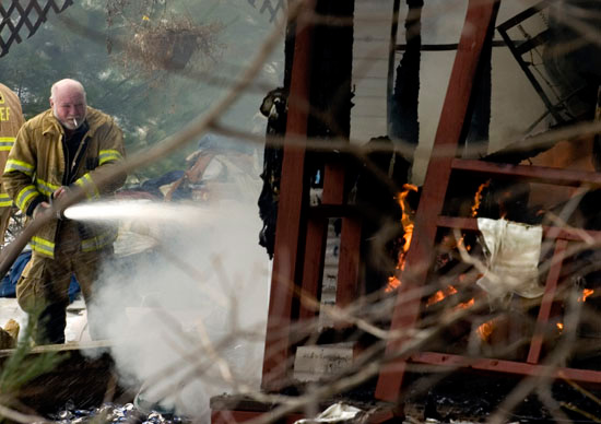  A Green Township Firefighter smokes a cigarette as he works to extinguish a fire in Williamsport. The fire destroyed John Rankin's historic home. 