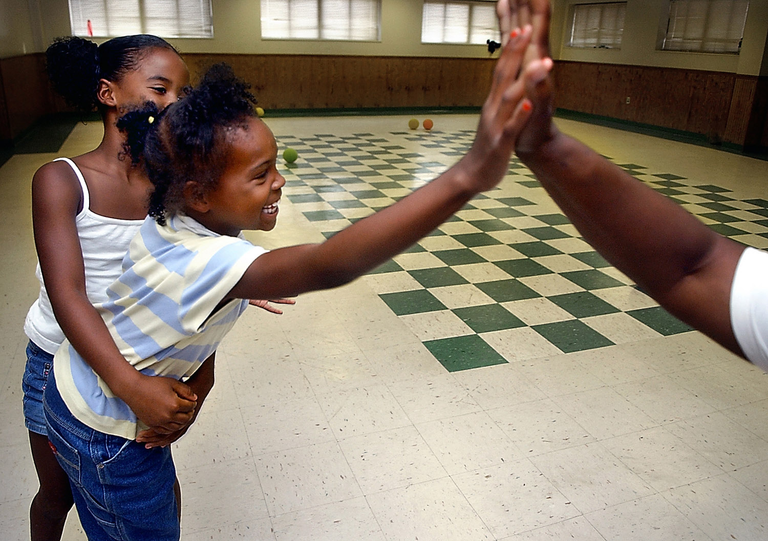  Destiny Howard, 8, the last girl standing during a game of "Star Wars," gets a hug and a high-five after beating the boys. 