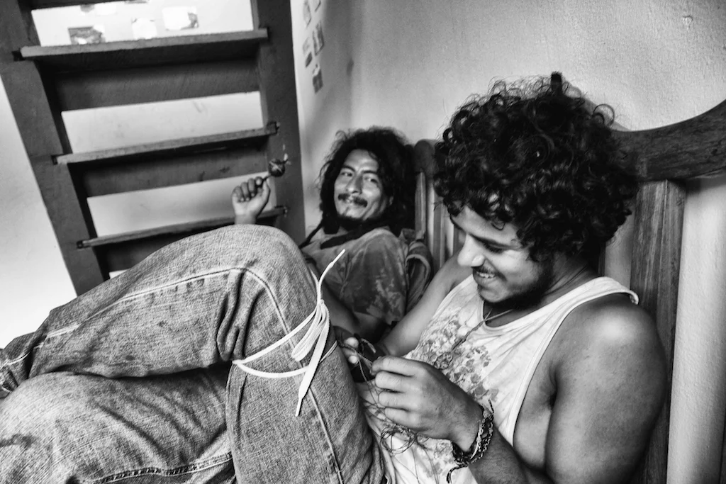 Christian and Jesús weave bracelets in the chacra 
