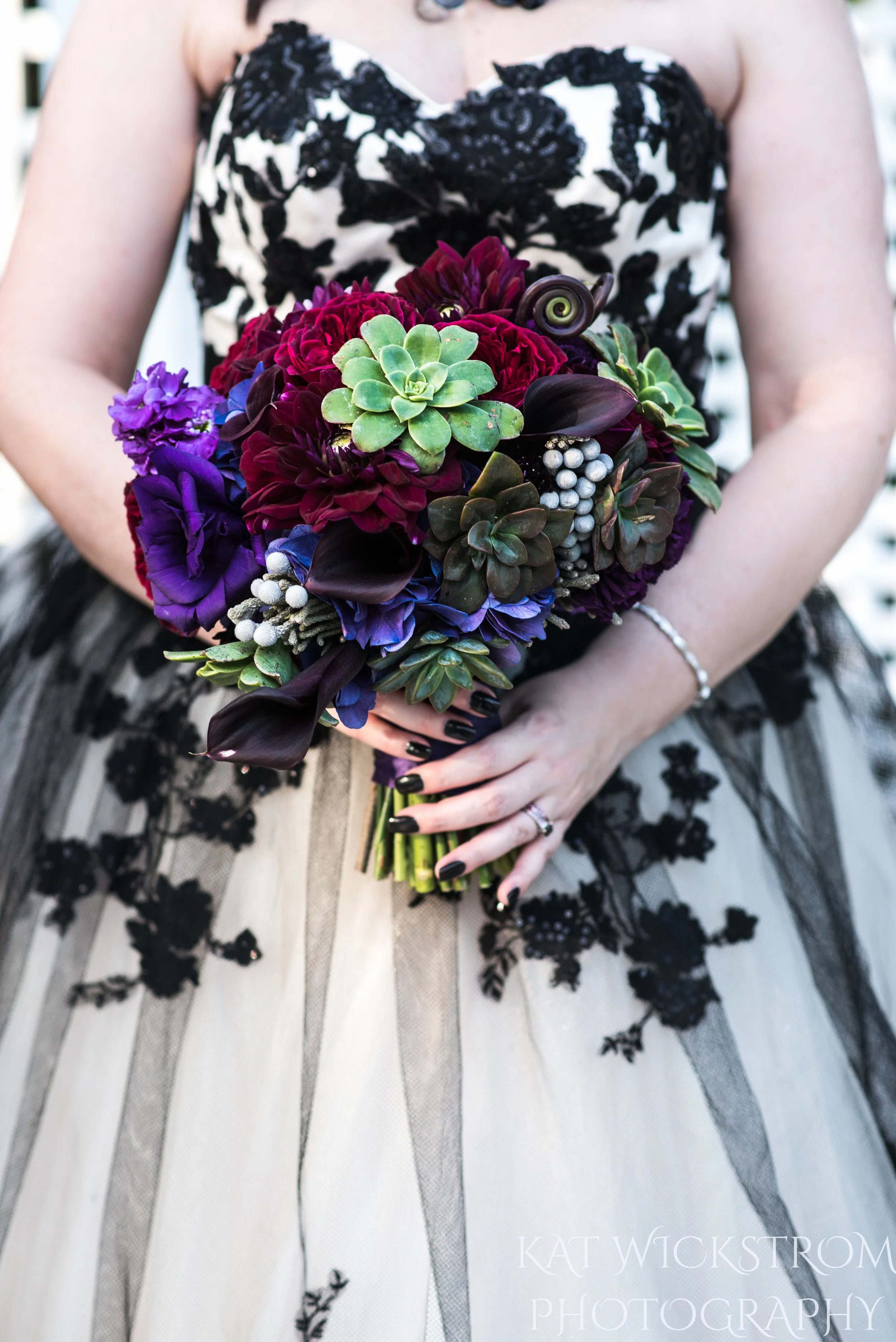 The bridal bouquet had succulents and dark purple flowers. They went perfectly with her black nails and dark theme.