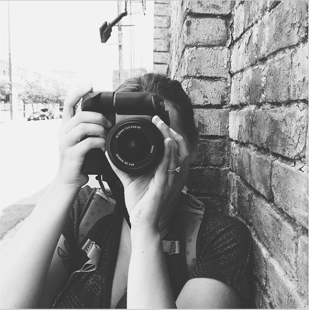 Kat Wickstrom, a girl, holds a camera for Kat Wickstrom Photography, a destination wedding and elopement photographer
