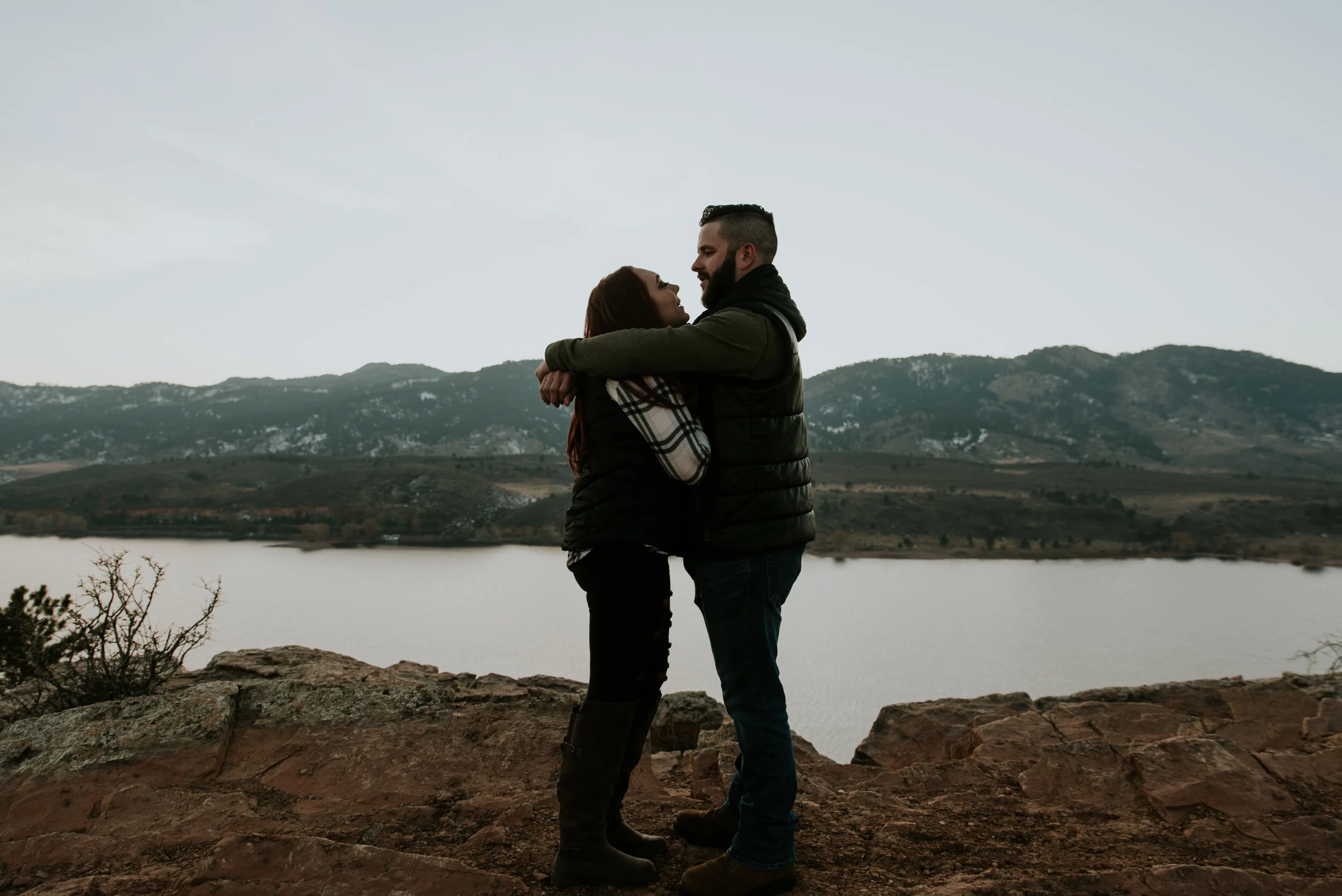 couple-embraces-on-mountain-during-engagement-shoot