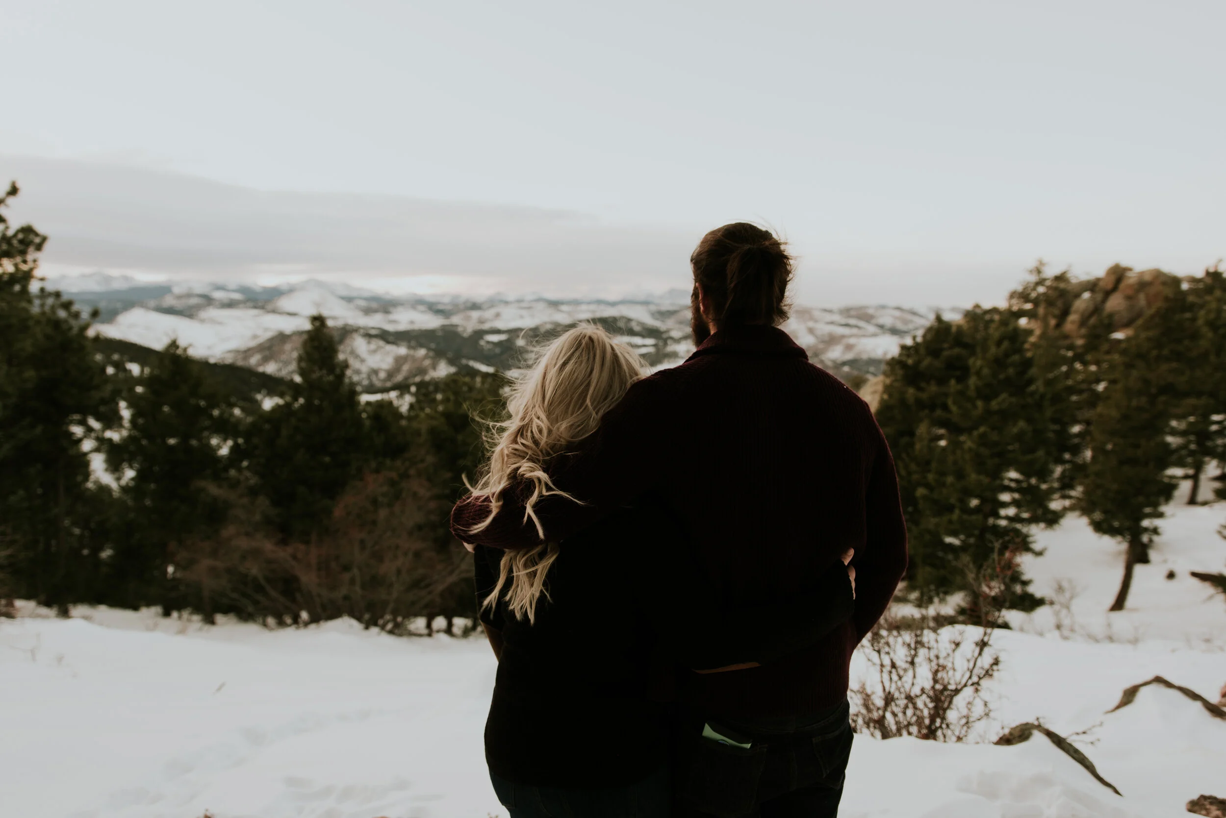 couple-looks-out-at-mountains-during-engagement-session