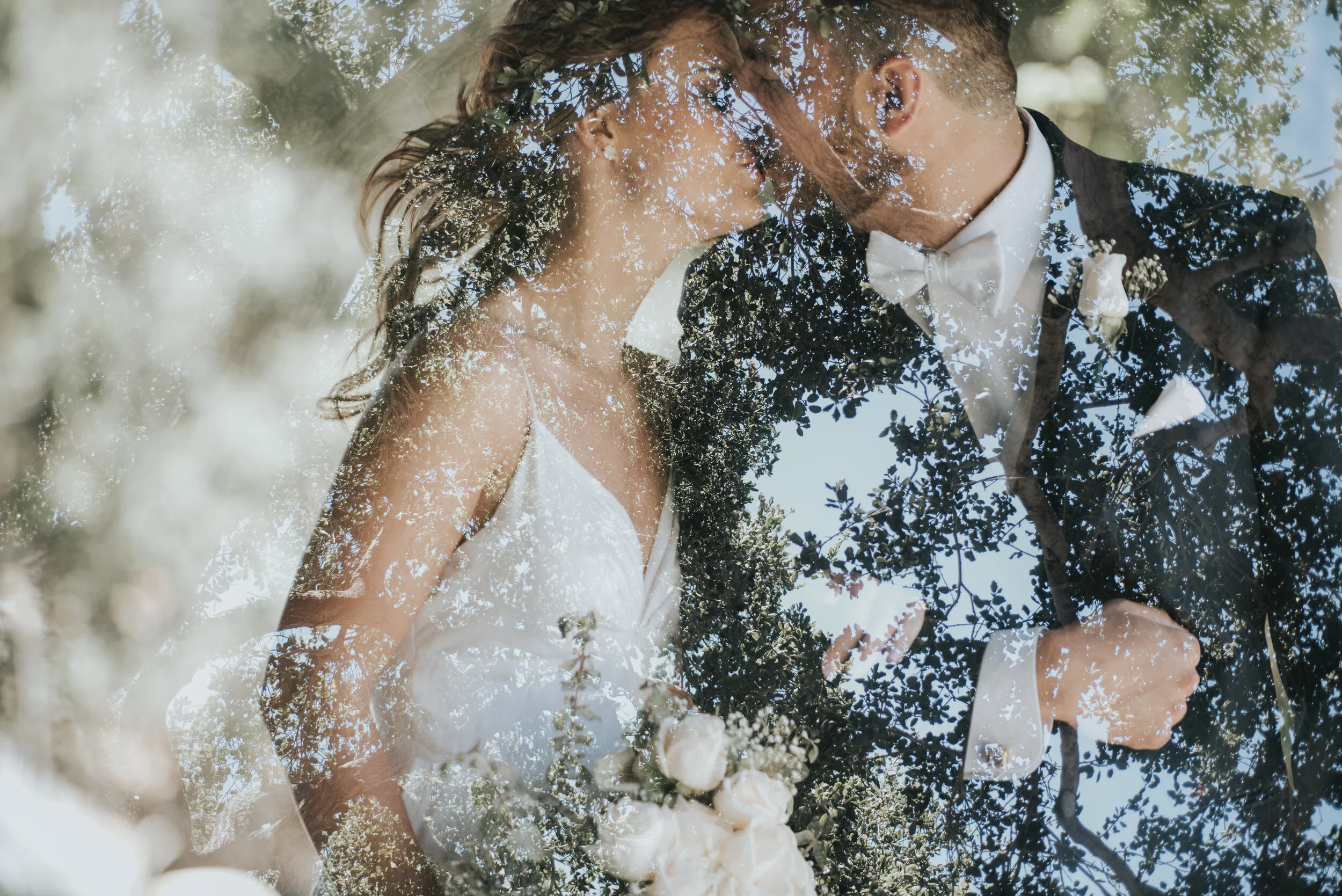 A double exposure image of a couple kissing during an ideal wedding timeline