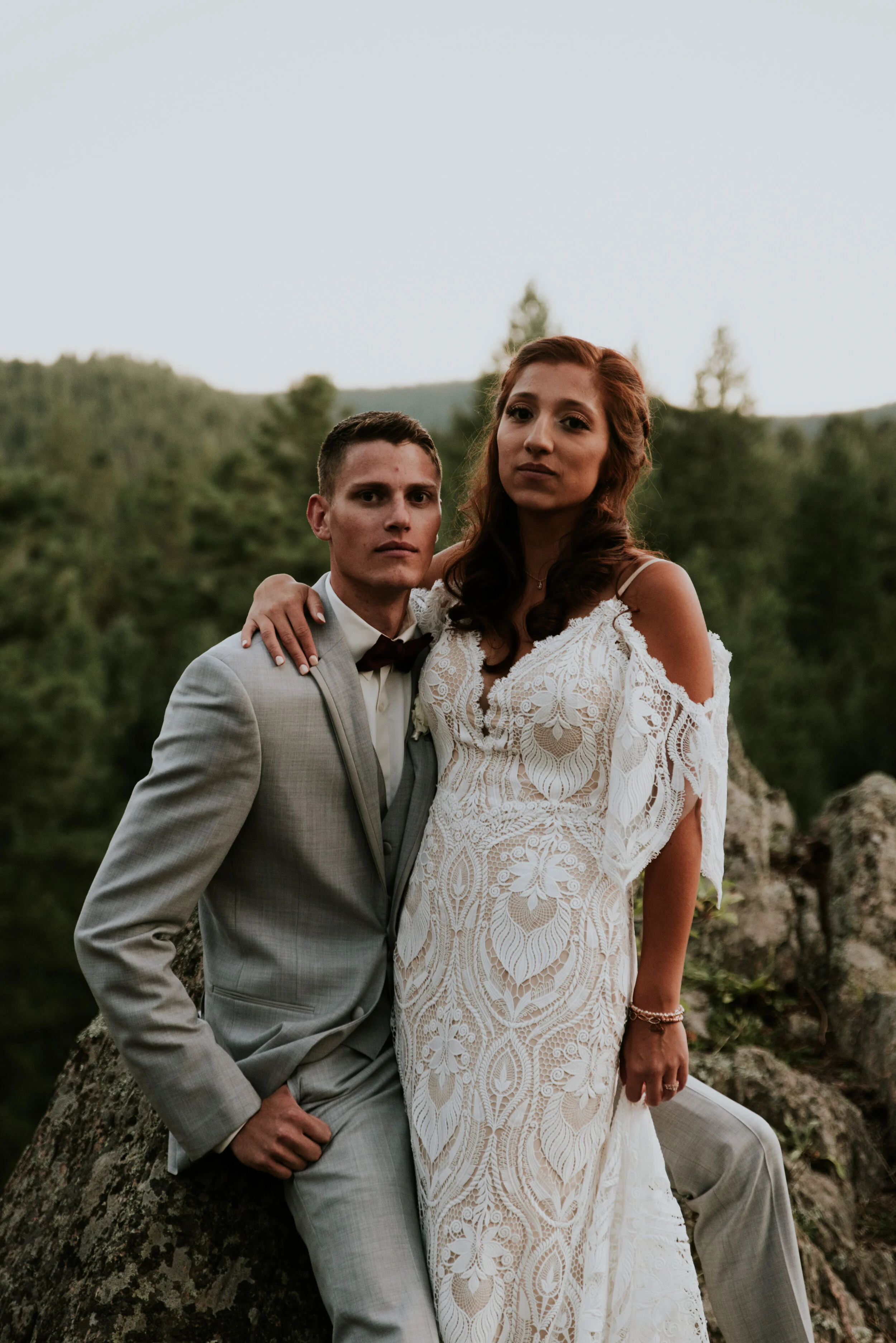 A couple embraces on a mountain after planning a destination wedding or elopement
