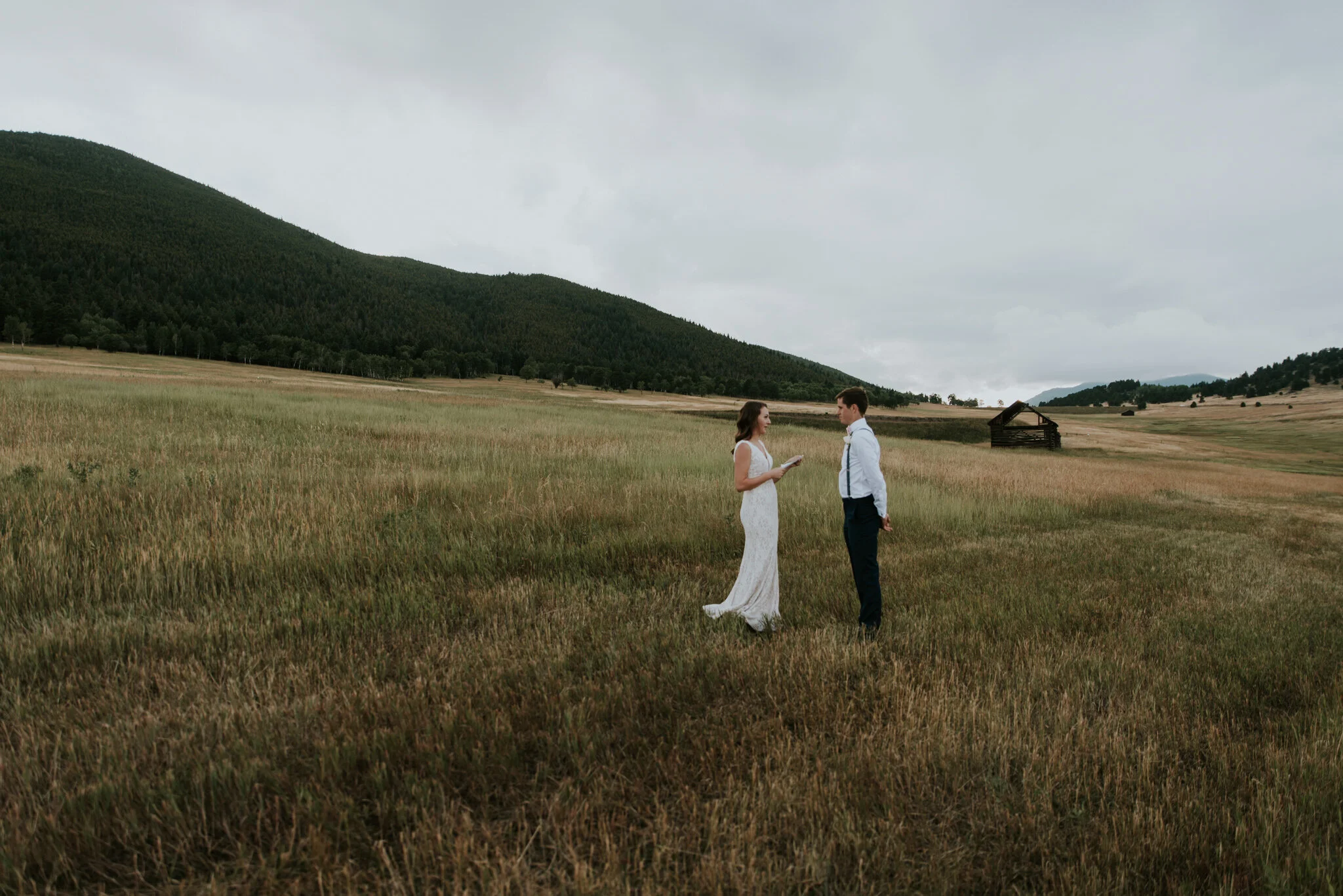 A couple exchanges vows in a field at Elk Meadow during an elopement after picking the perfect location for a destination elopement