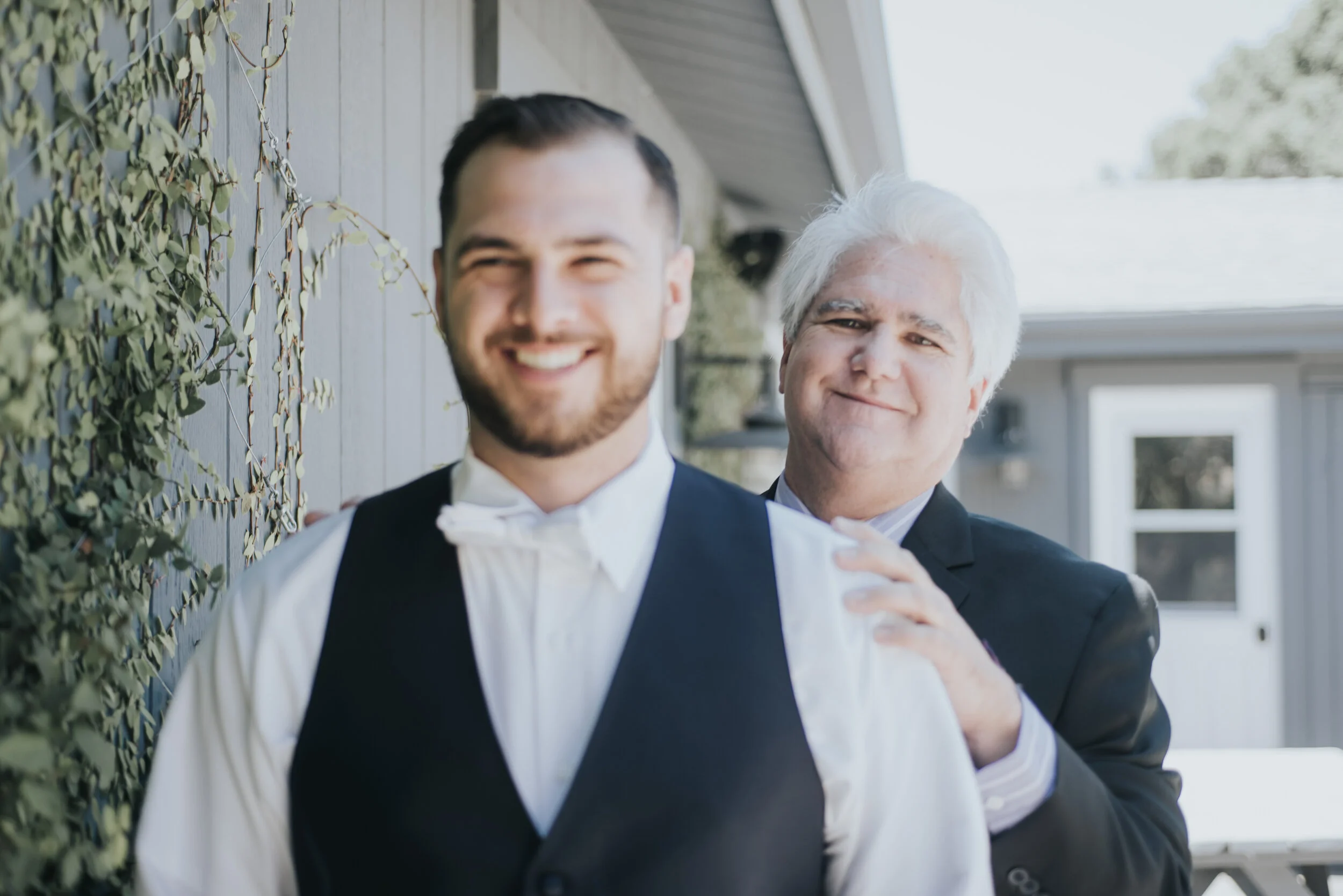 Father helps groom get ready during an elopement including family
