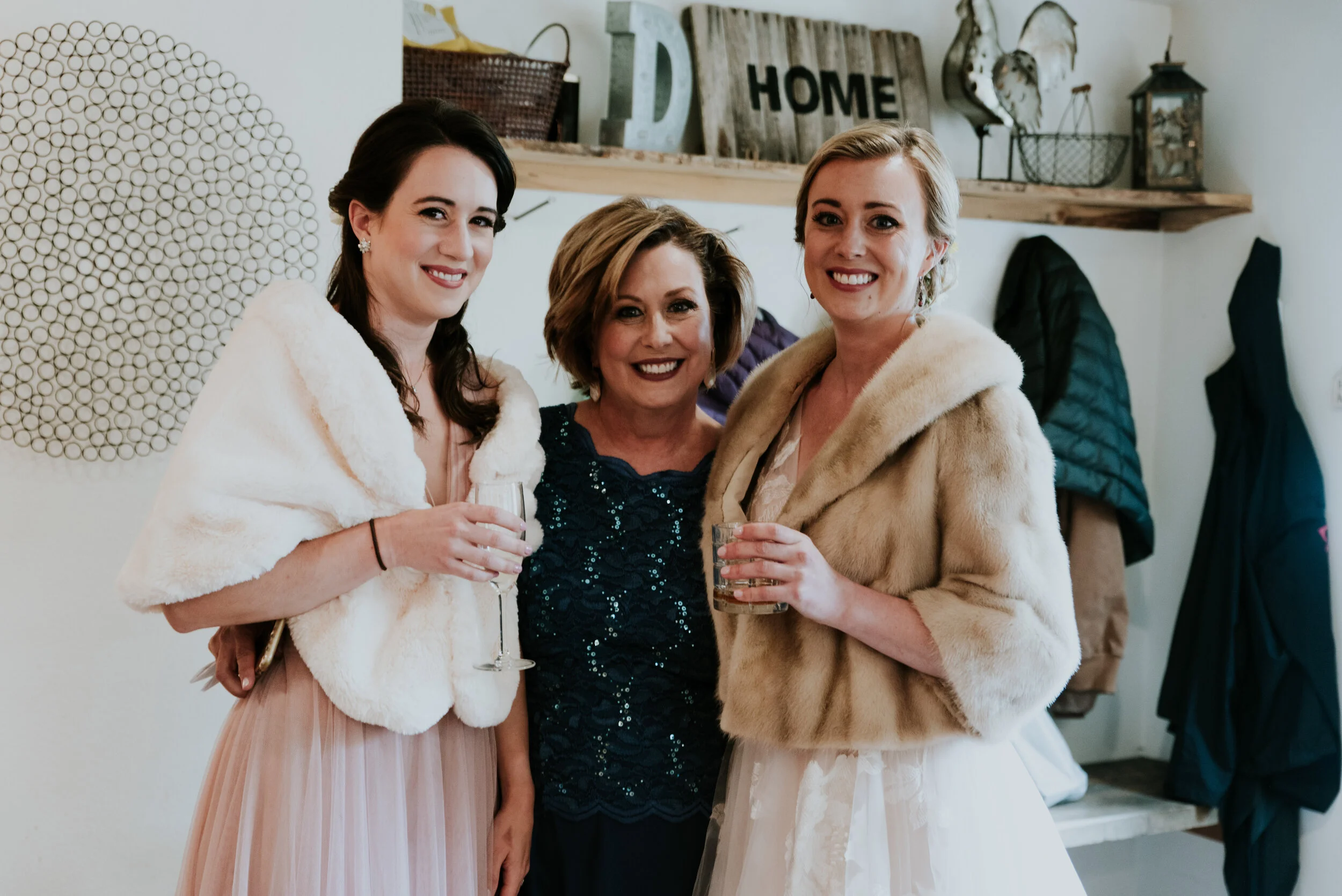 Mother and two daughters pose with drinks at an elopement that includes family