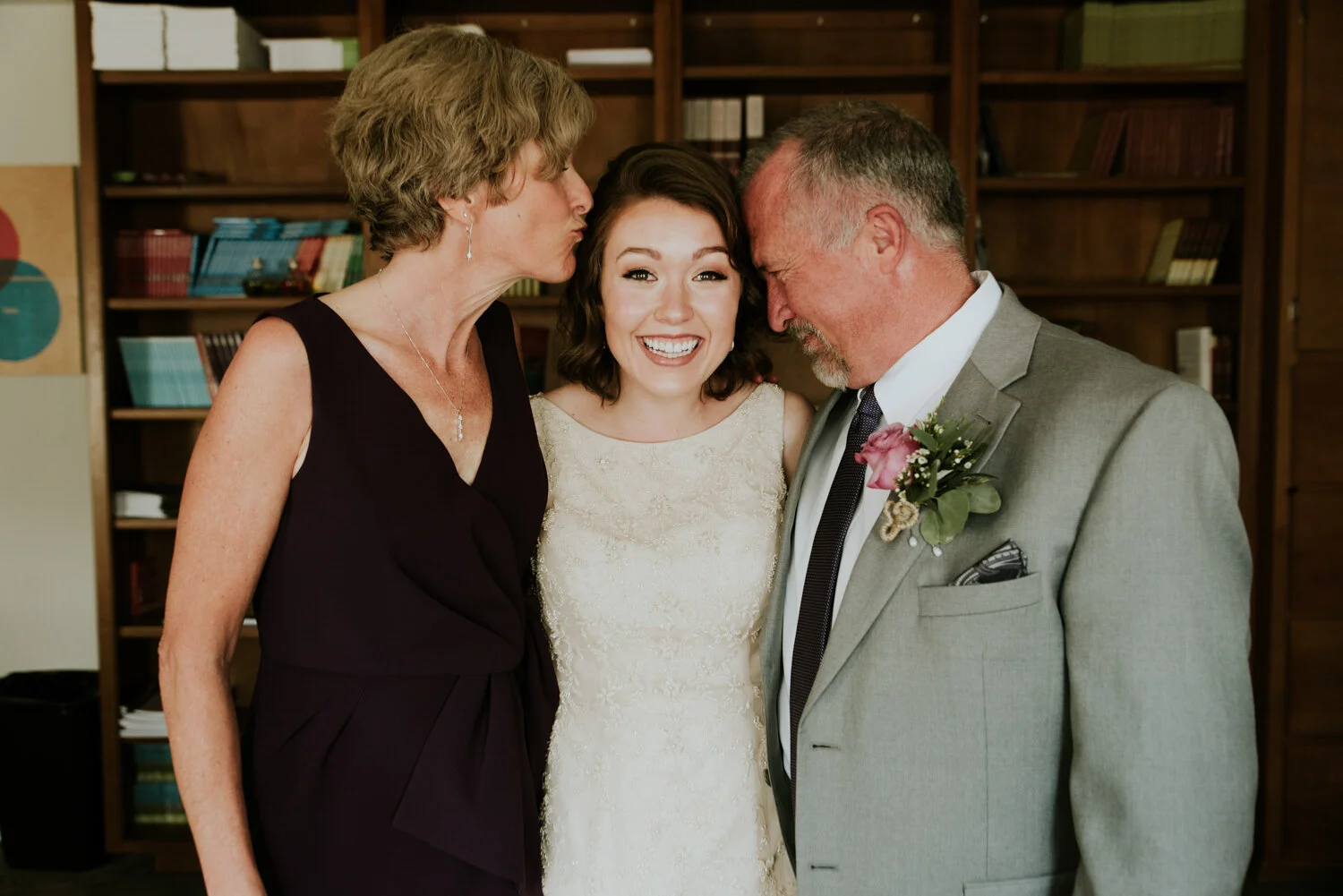 Mother and father poses with bride at an elopement with family