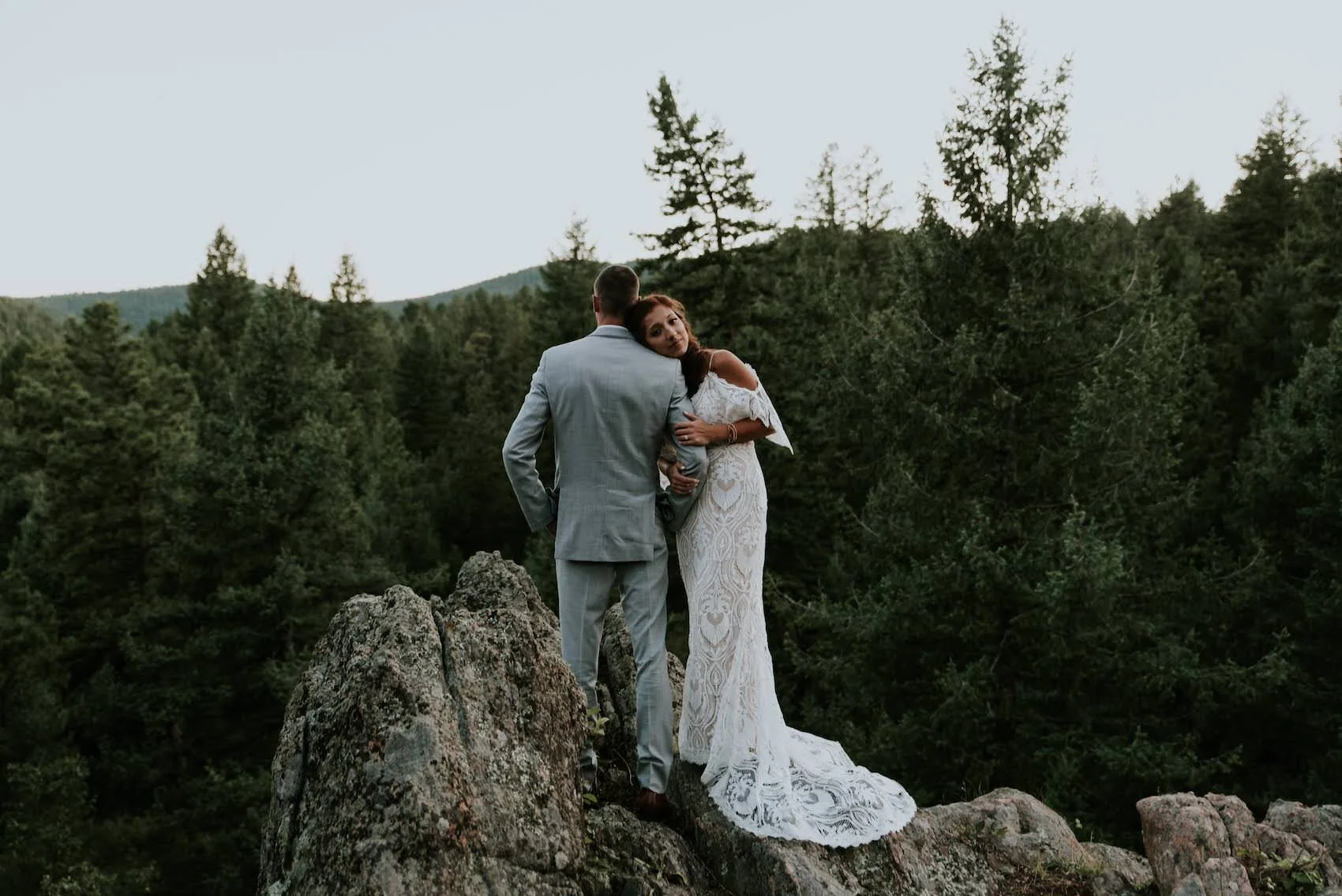Couple eloping in Colorado on top of a mountain overlooking the forest
