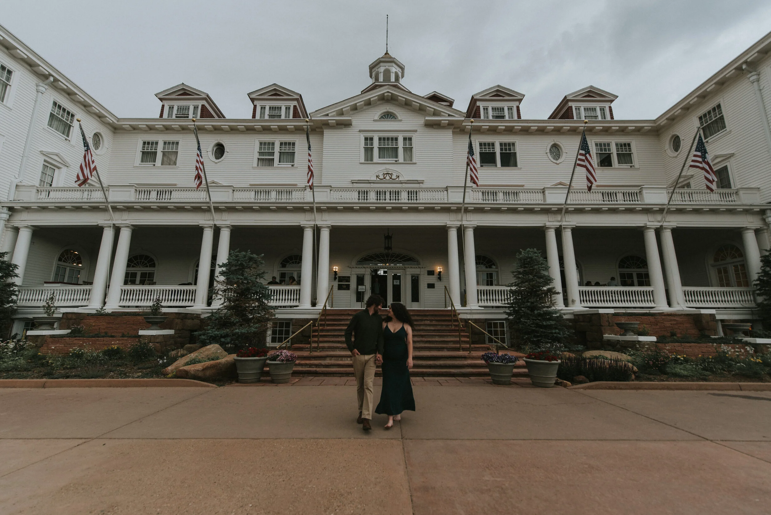 Couple_walks_in_front_of_the_stanley_hotel_in_estes_park