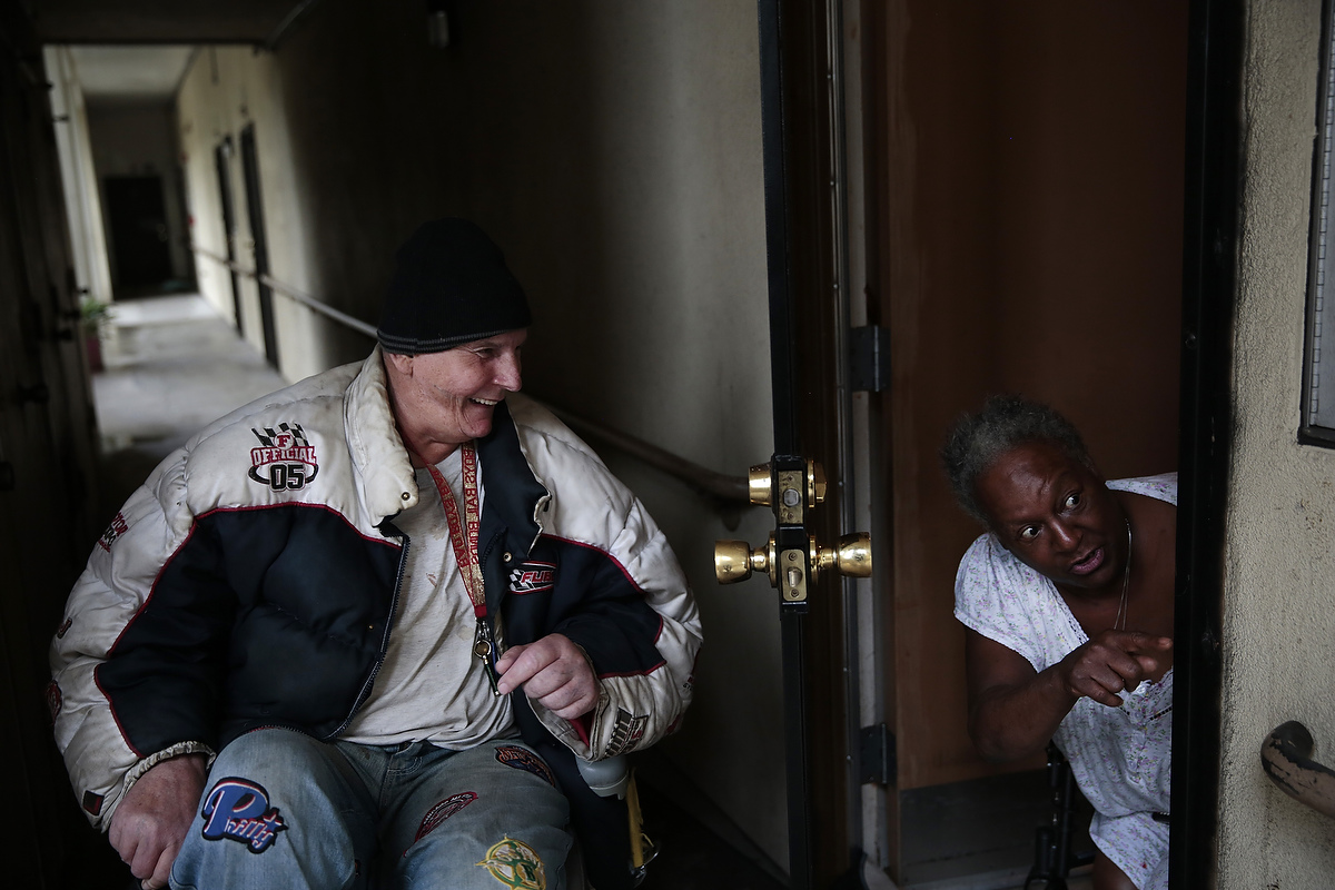Resident Everett Dennis Lewis, 62, laughs at friend and fellow resident Rhonda Marshall, 59, as she talks with her neighbor at the Hacienda housing complex in Richmond, California, Friday, February 6, 2015. 