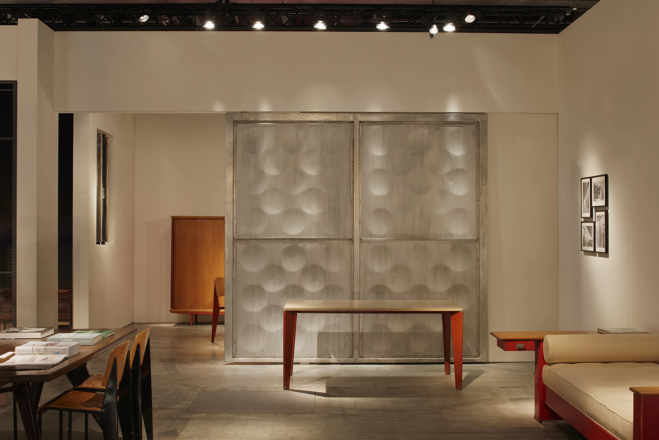 Jean Prouvé room setting at Galerie Patrick Seguin - Design Miami/ Basel with Casino Solvay Table, CA. 1942 (center) and Scal No. 450 BED CA. 1951 (right) ⓒ James Harris