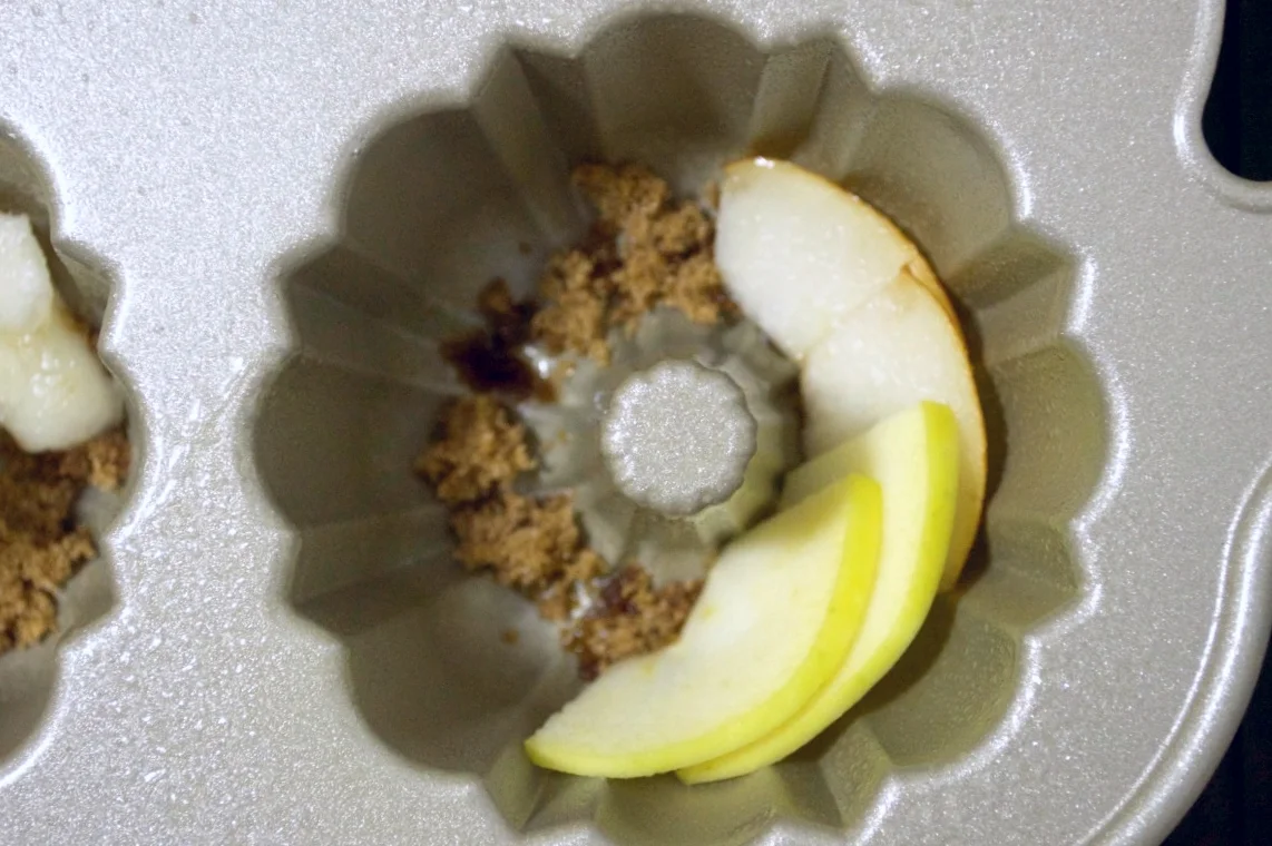 fanning the apple and pear slices around the the bottom of the bundt pans will give these cakes a pretty top. the extra bit of brown sugar underneath ensures everything stays in place and adds a lovely, caramelized sweetness to the fruit.