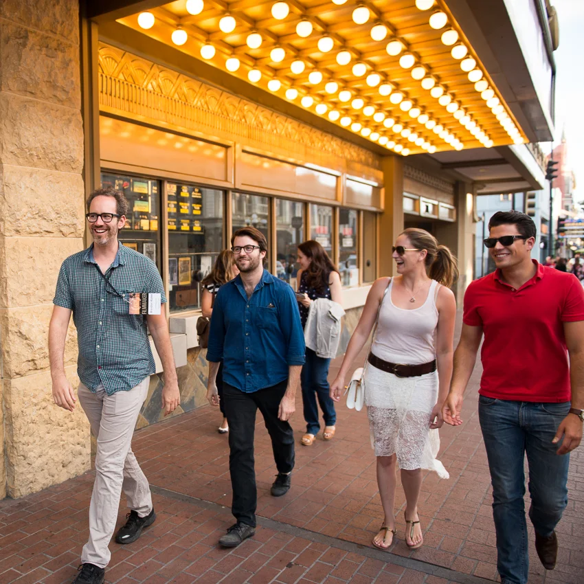  Cast & Crew strolling down 5th Avenue under the Reading Theater marquee 