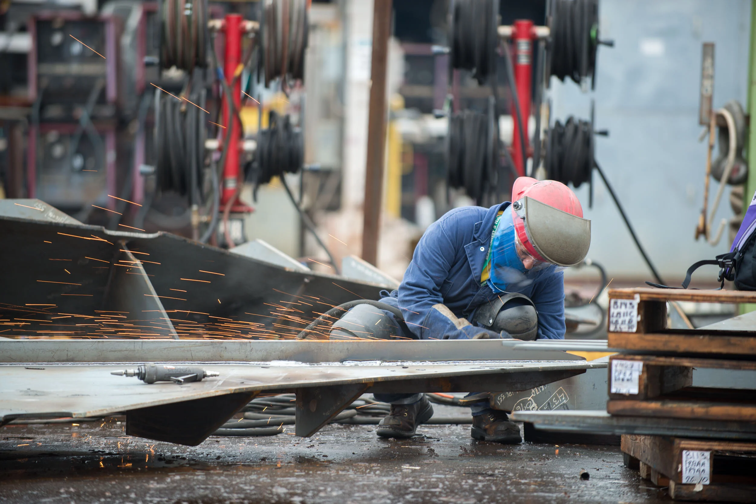 Shipbuilder grinds steel plate