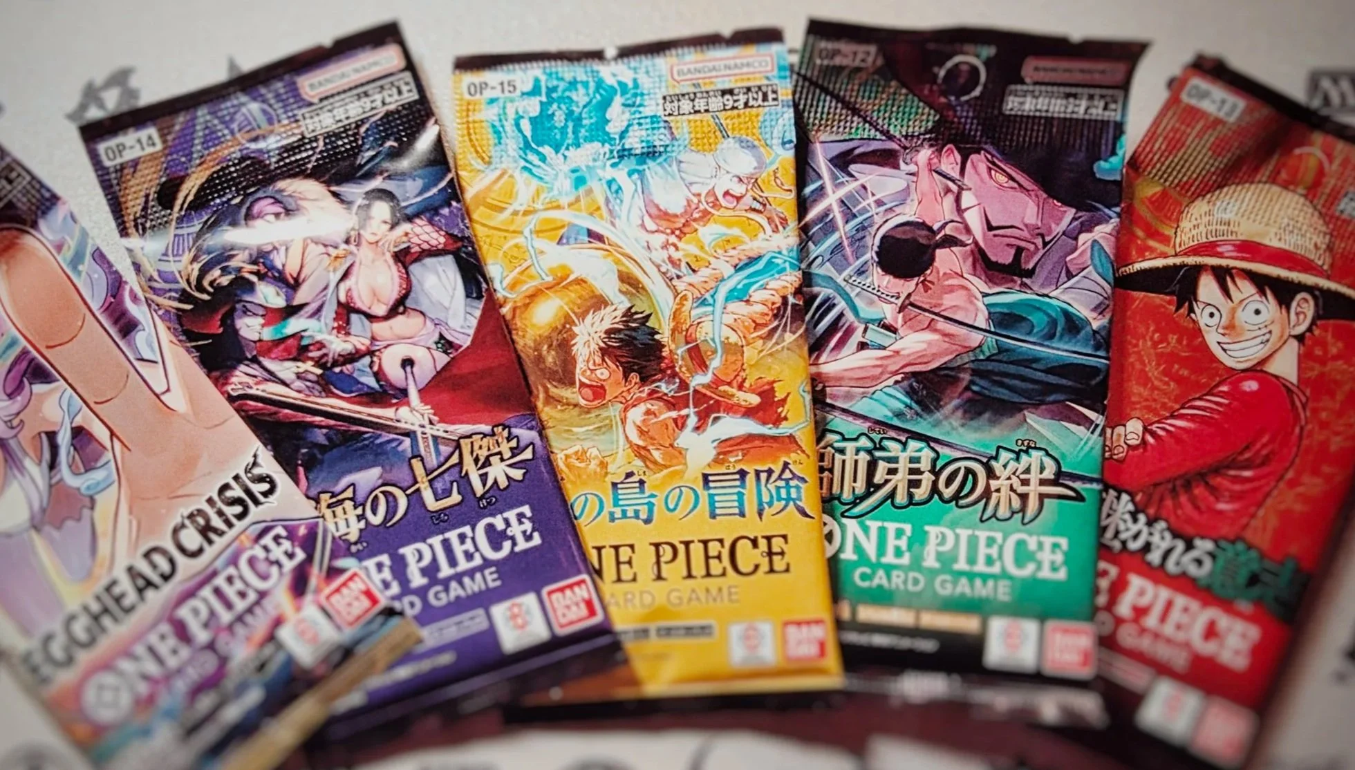 Pacchetti di carte da gioco della serie One Piece con personaggi anime, tra cui Monkey D. Luffy e altri personaggi del manga e anime.