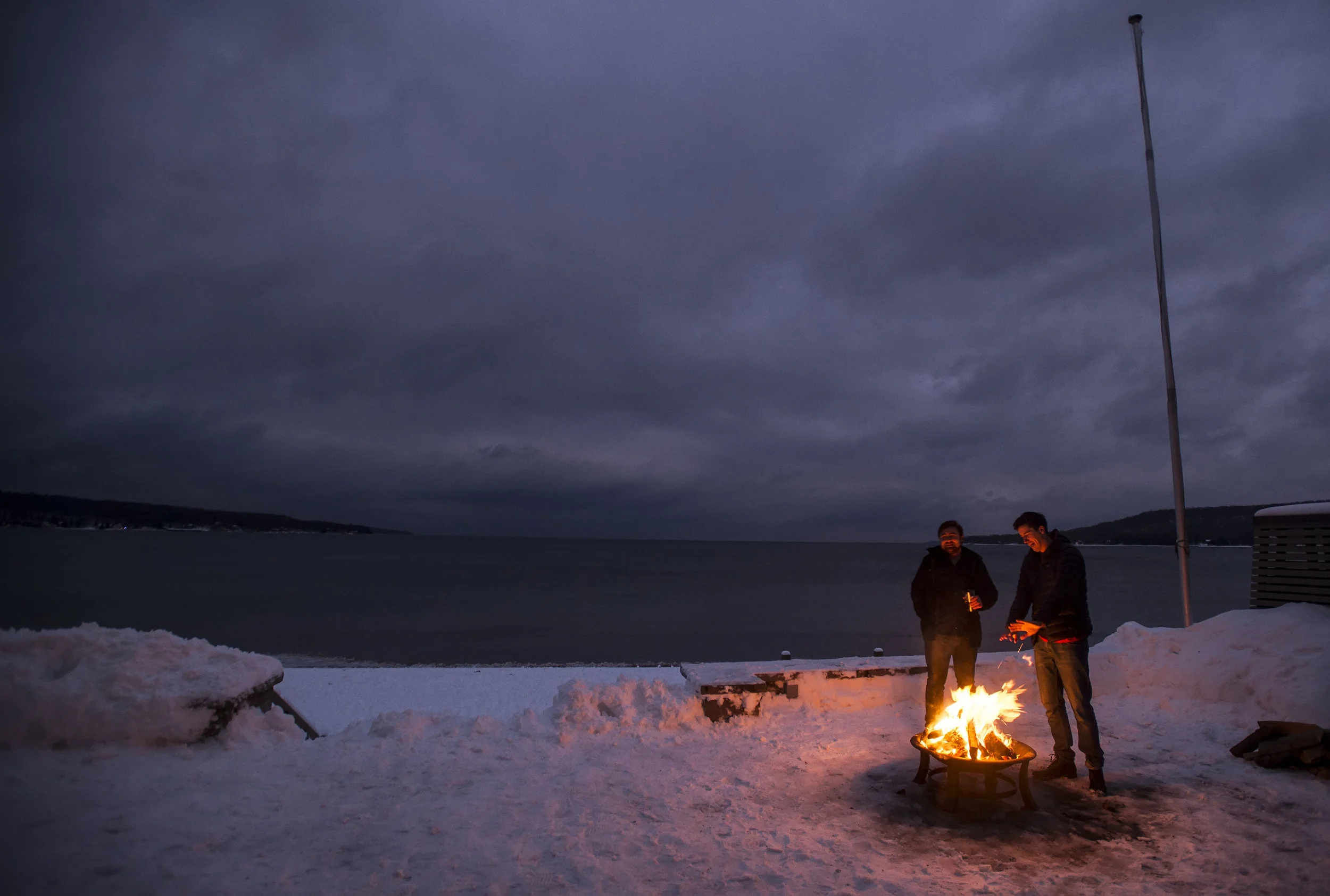  Jack Davies, left, and Brandon MacGregor keep warm at a cottage on Thunder Beach during a New Year's Eve party. 
