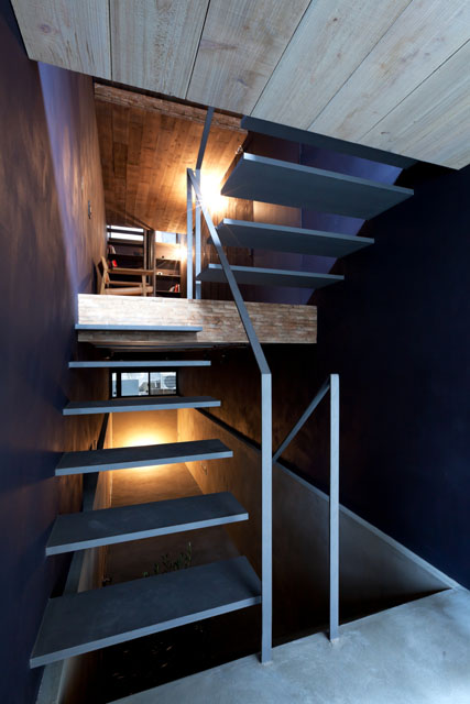 Both staircases consist of steel treads without supporting risers, and slender handrails allowing light to filter through. 