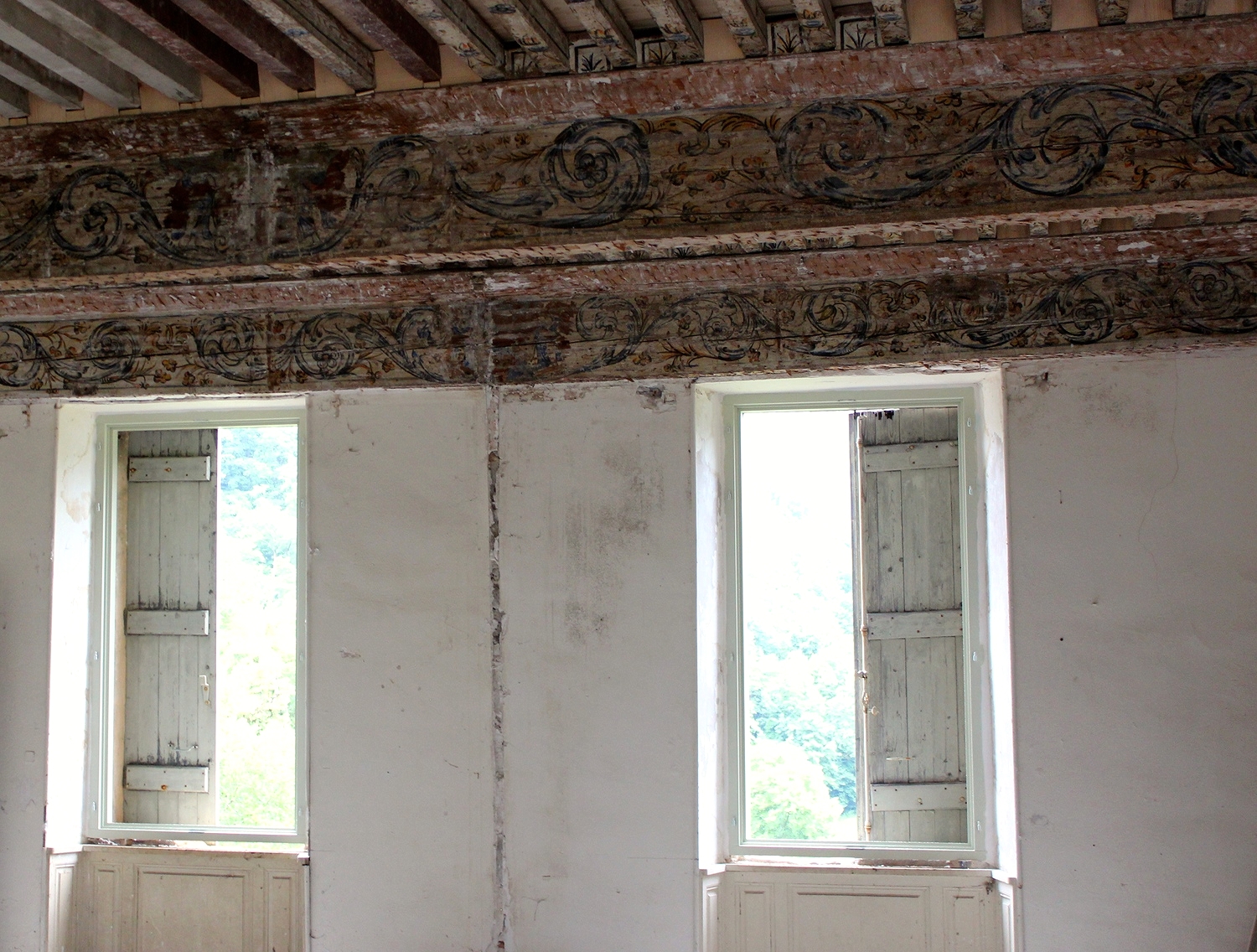 The white paint on the front beam (left of the picture) conceals the family crest. The beam above the windows has had the crest erased, almost centre of the windows.
