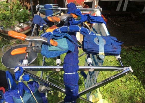 For a "tie dyed" look, bunch up fabric and tie with elastic bands. For square designs, accordion fold your fabric. For a circle pattern, clap a washer to the fabric before dyeing.