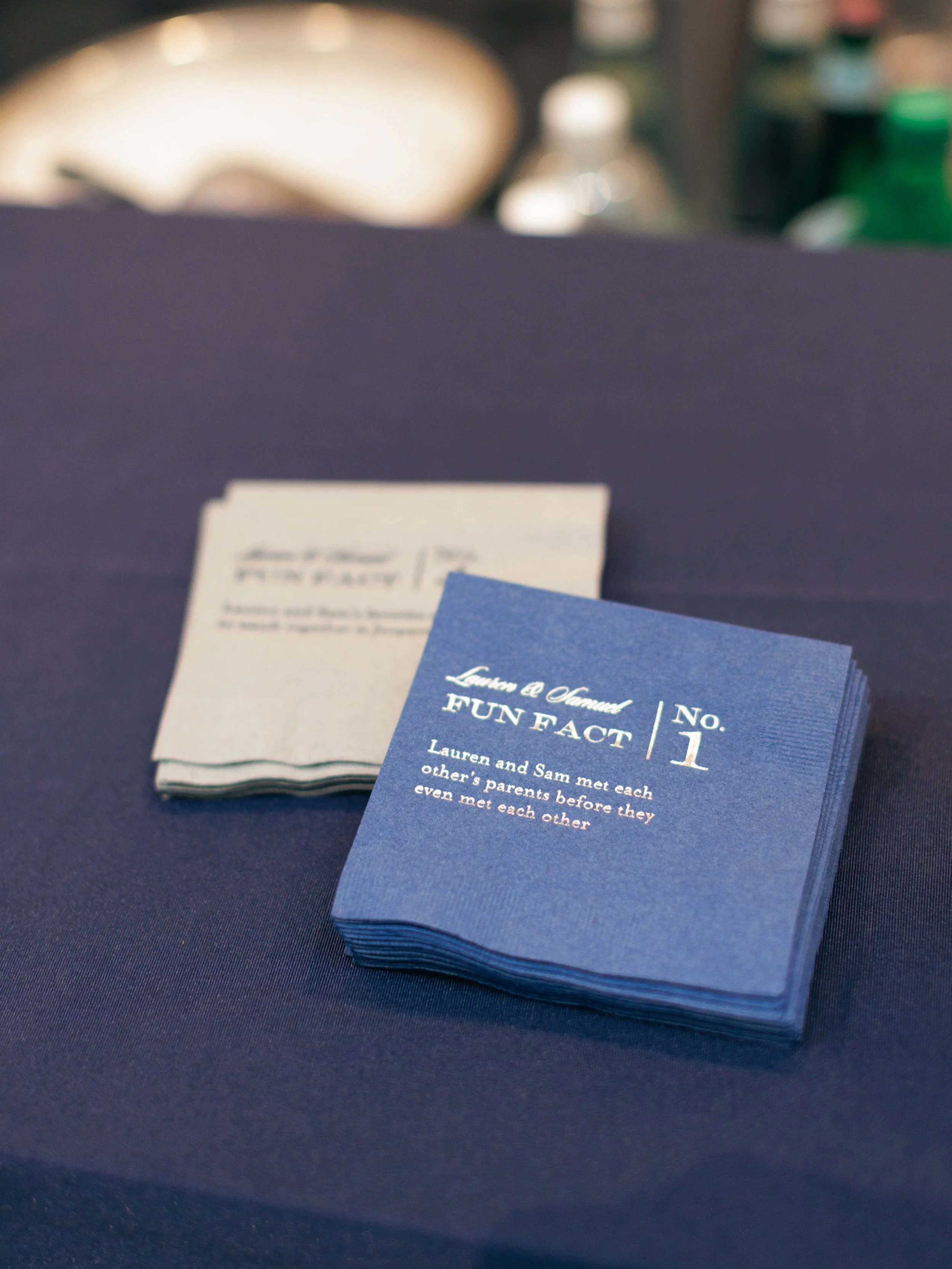 Close-up view of a stack of blue informational cards or pamphlets on a dark blue table, with the top card displaying some text and the title 'FUN FACT 1'