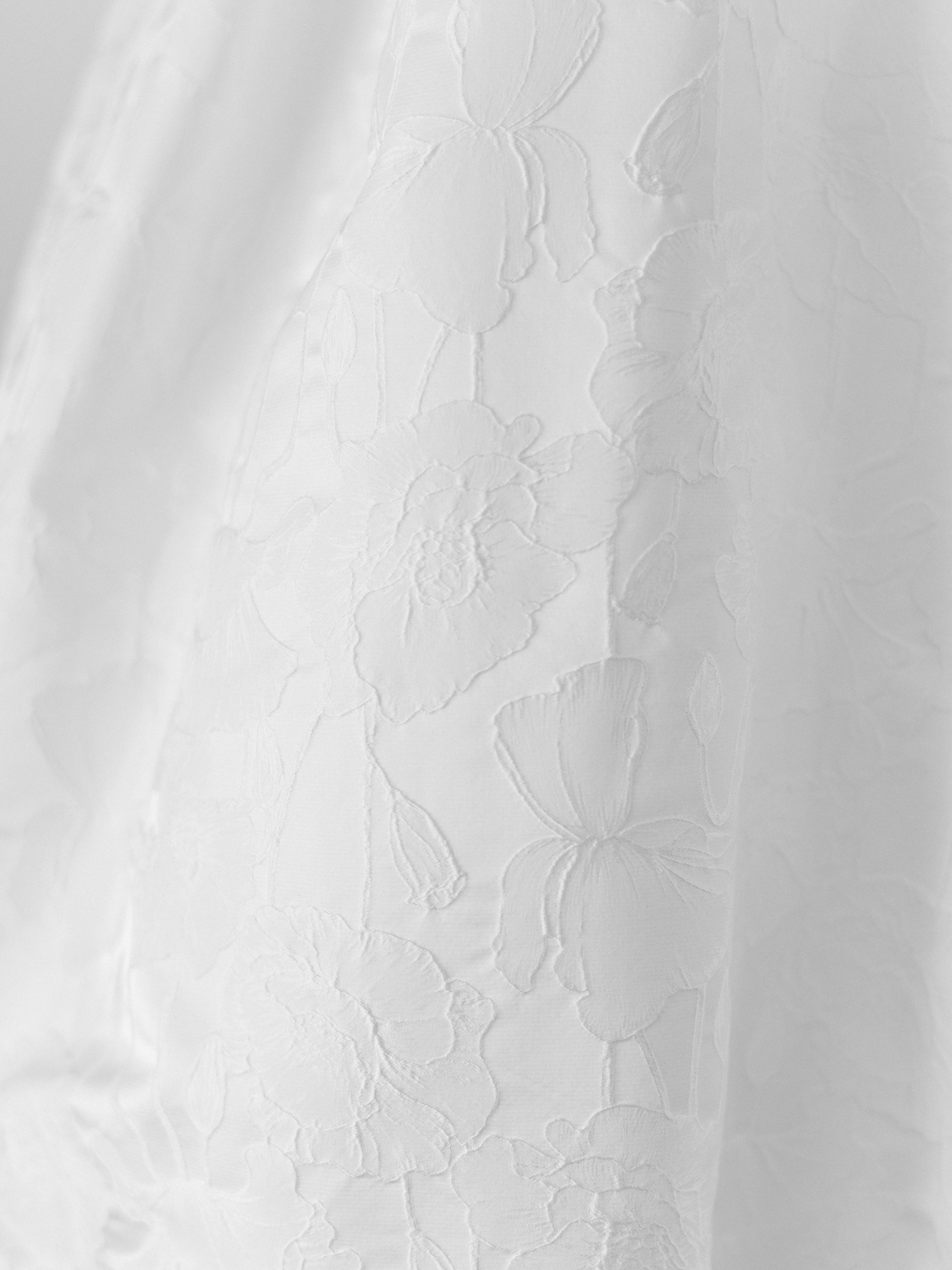 Close-up of a textured white surface with floral embossed patterns.