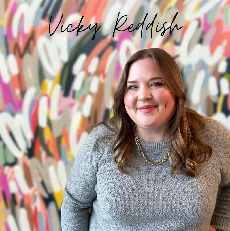 image of woman smiling in front of colorful painting