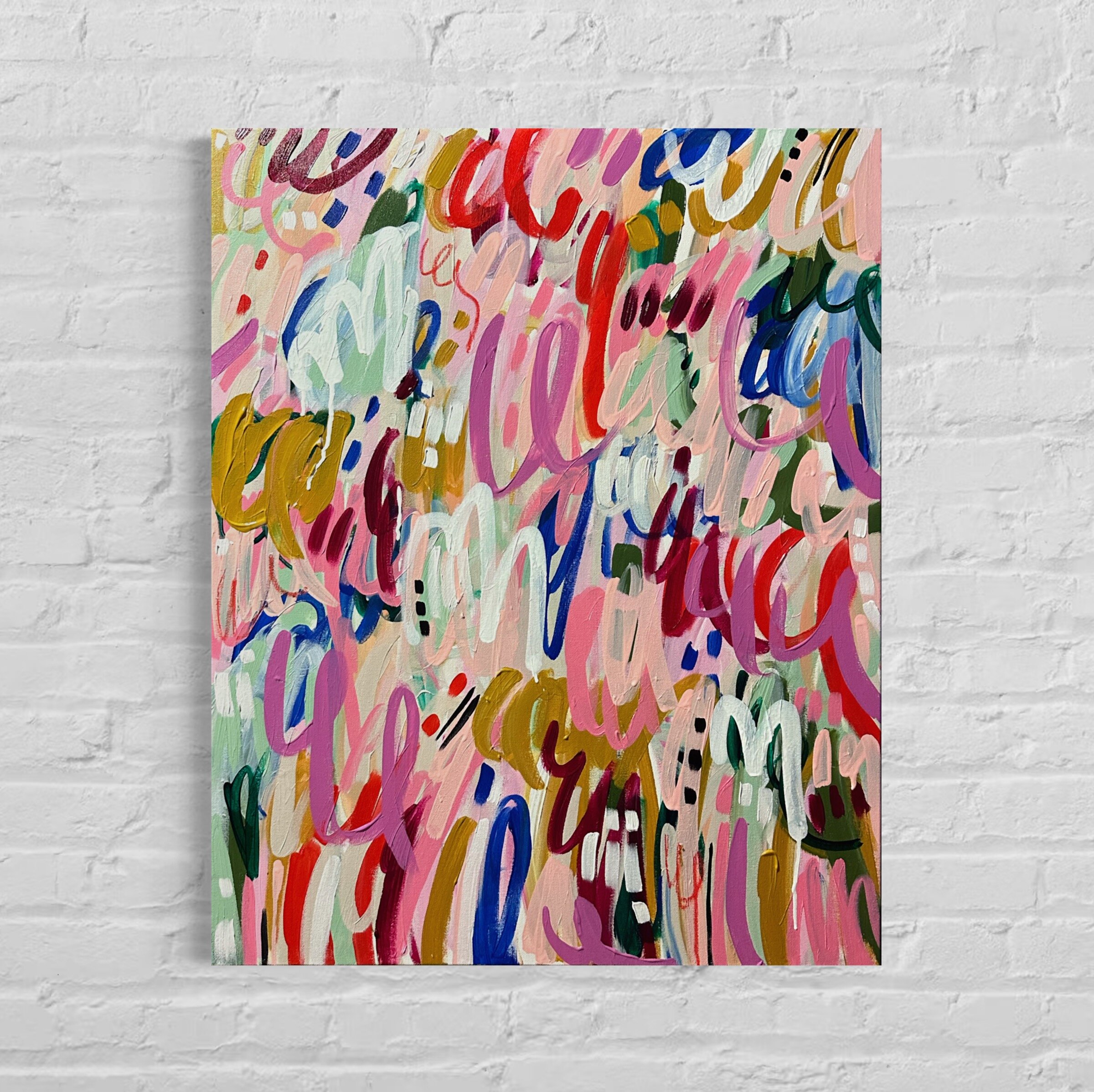An abstract painting with colorful, overlapping brushstrokes on a canvas, hung on a white brick wall.