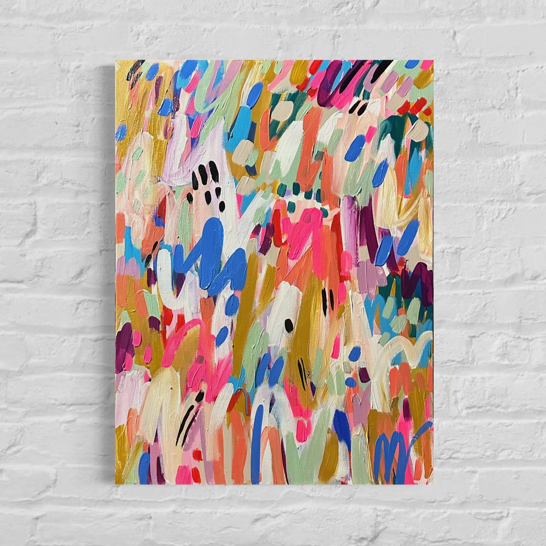 Abstract colorful acrylic painting on canvas, featuring bold brushstrokes in pink, blue, green, orange, black, and white against a white brick wall background.