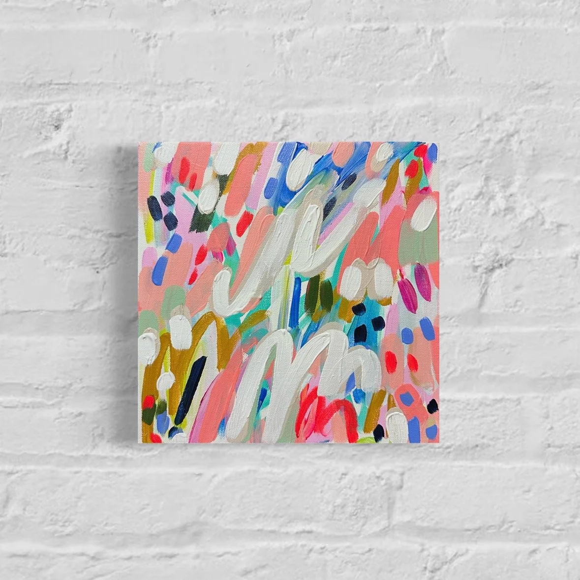 Colorful abstract painting on a white brick wall background.