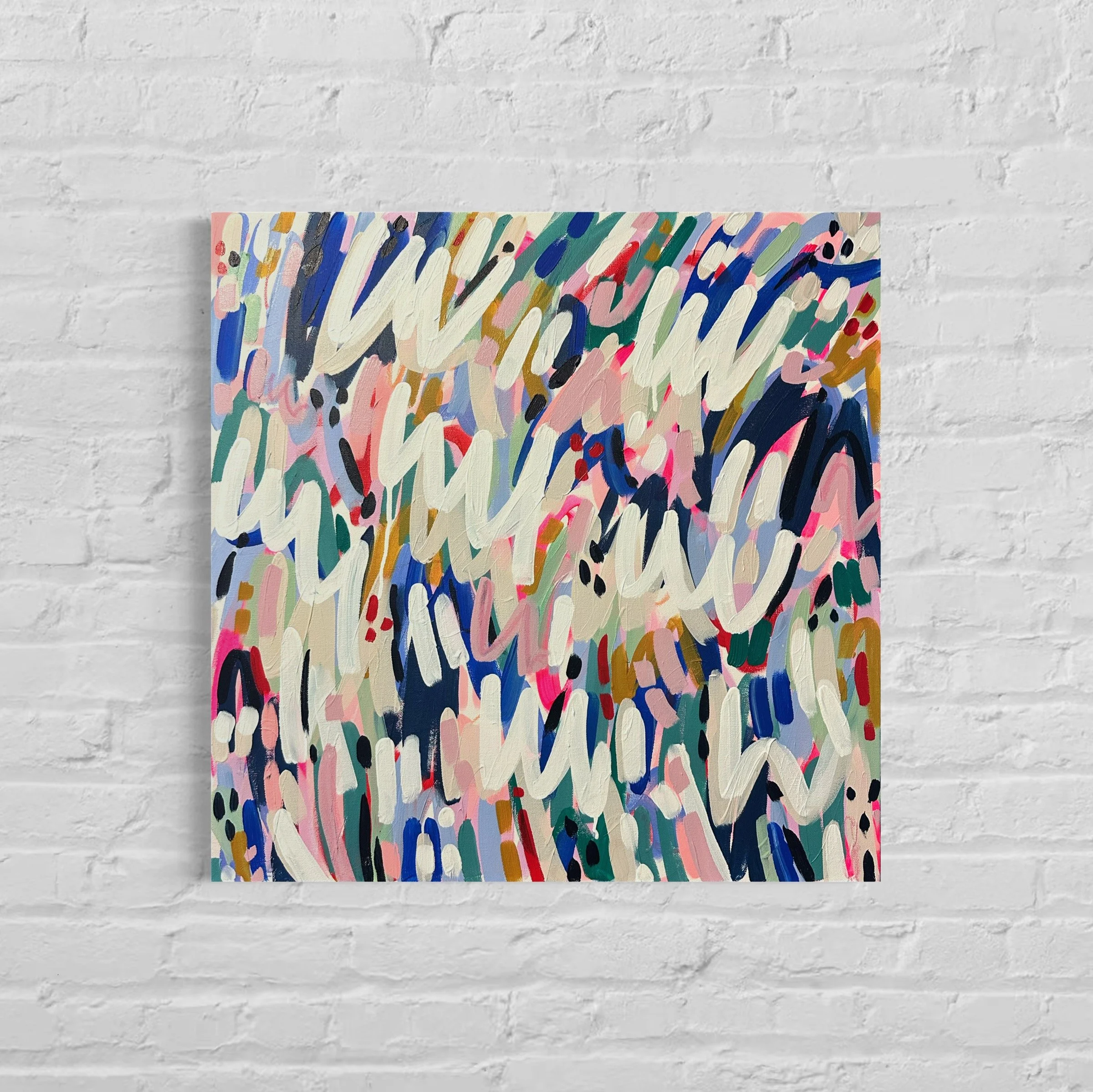 Abstract colorful painting with chaotic brushstrokes in various colors, on a canvas against a white brick wall.