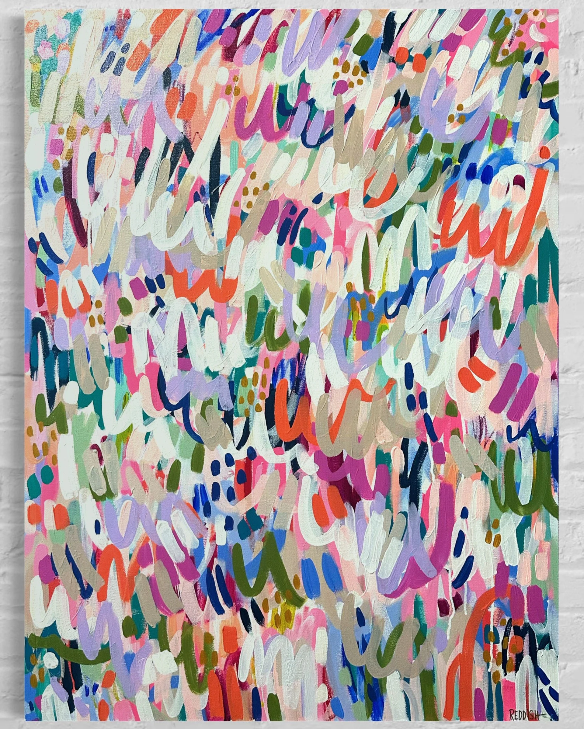 An abstract, colorful painting with overlapping brushstrokes in shades of pink, purple, blue, green, orange, white, and beige. The painting contains various shapes and patterns, including dots and curved lines, arranged randomly across the canvas. Th