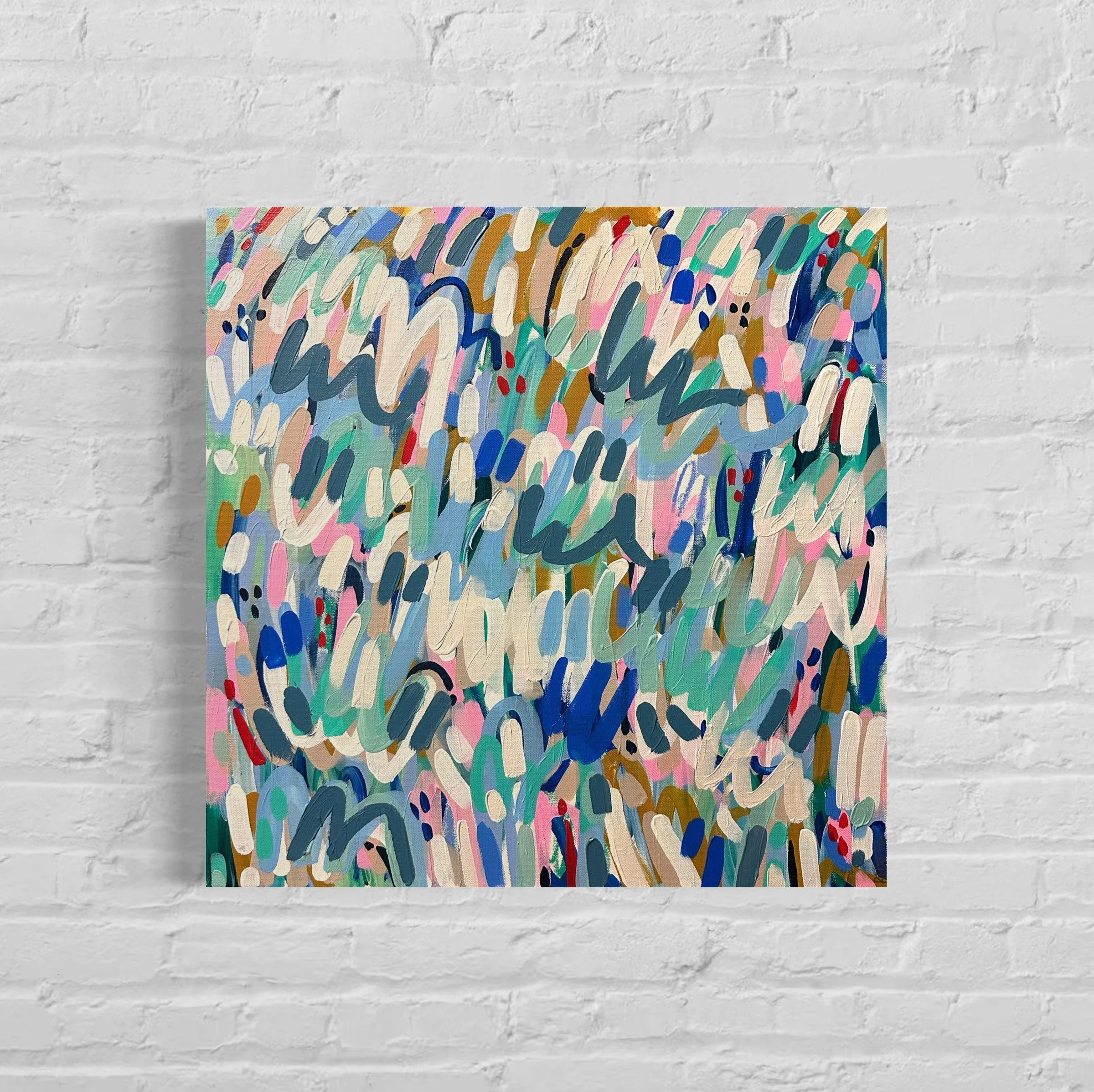Colorful abstract painting with various curved brushstrokes in pink, blue, green, white, black, and gold, mounted on a white brick wall.