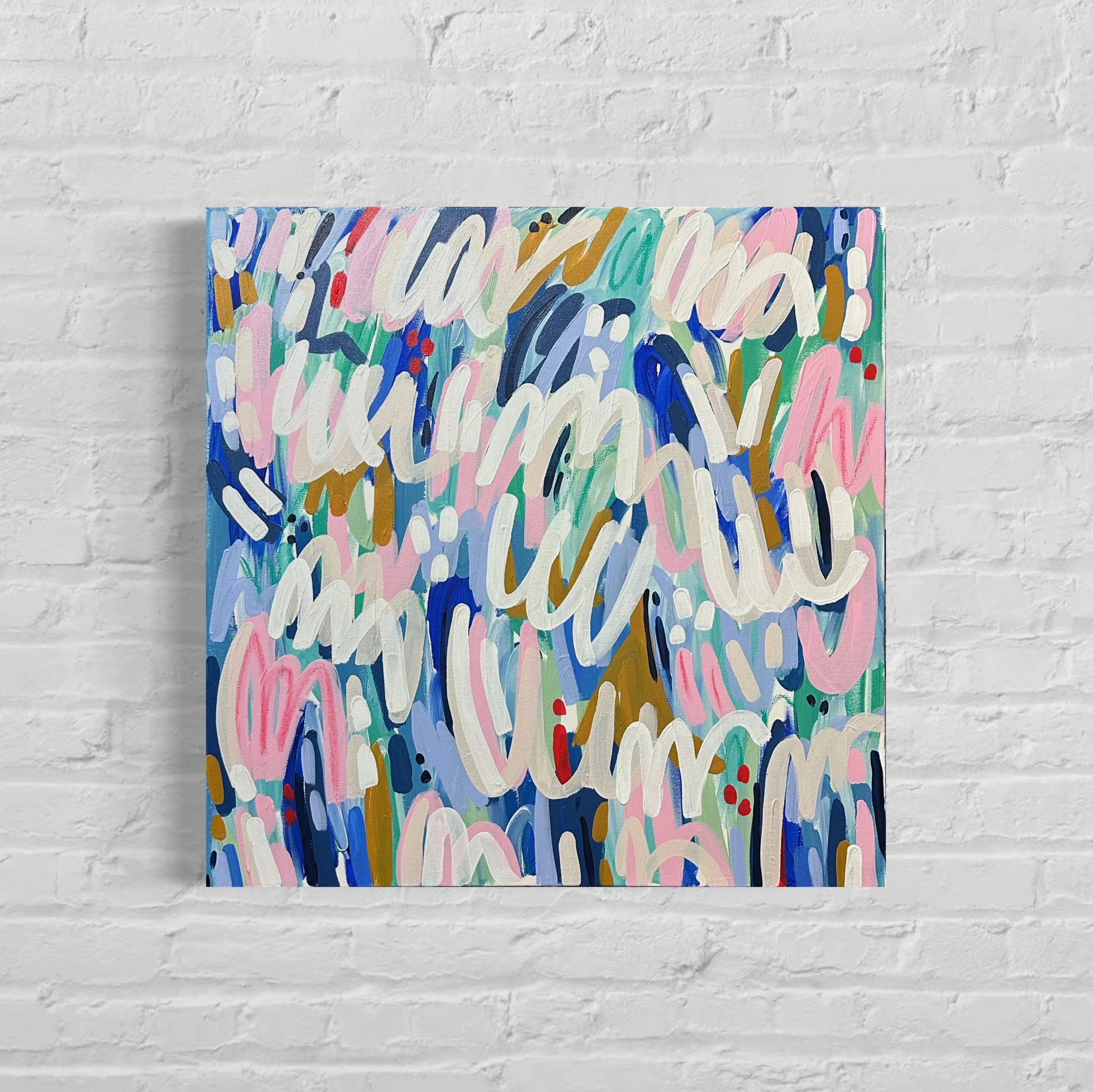 An abstract painting with colorful, curved brushstrokes on a canvas, placed against a white brick wall.